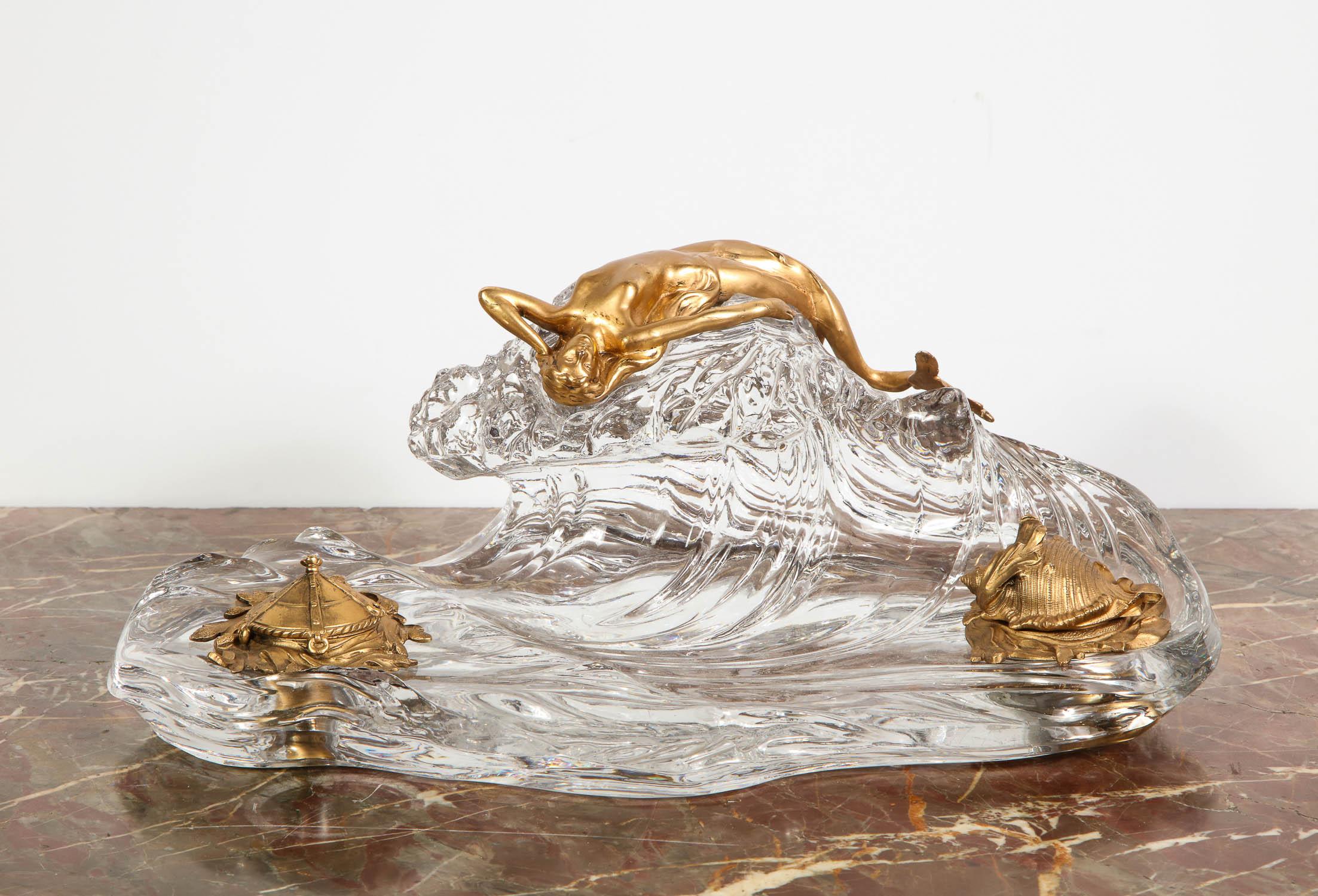 Art Nouveau French gilt bronze and crystal Nautical Mermaid Inkwell, attributed to Baccarat, circa 1910

Featuring a fantastic large wave-form crystal with a bronze figural mermaid and lidded gilt bronze ink receptacles. 

An example of this