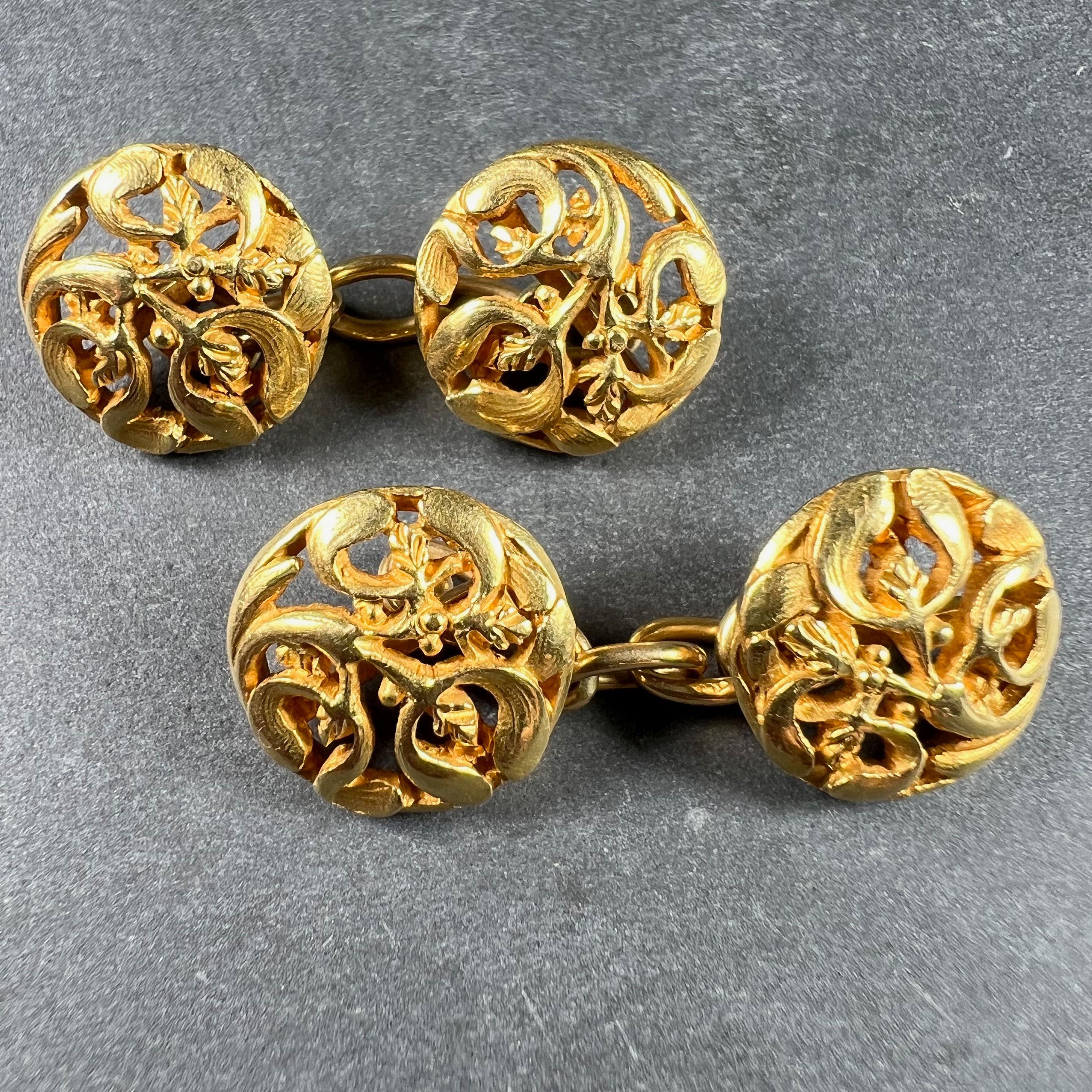 A pair of French Art Nouveau 18 karat (18K) yellow gold cufflinks designed with a pattern of mistletoe leaves. Stamped with the eagle’s head for 18 karat gold and French manufacture and numbered 44340 with a partial maker's mark to one of the