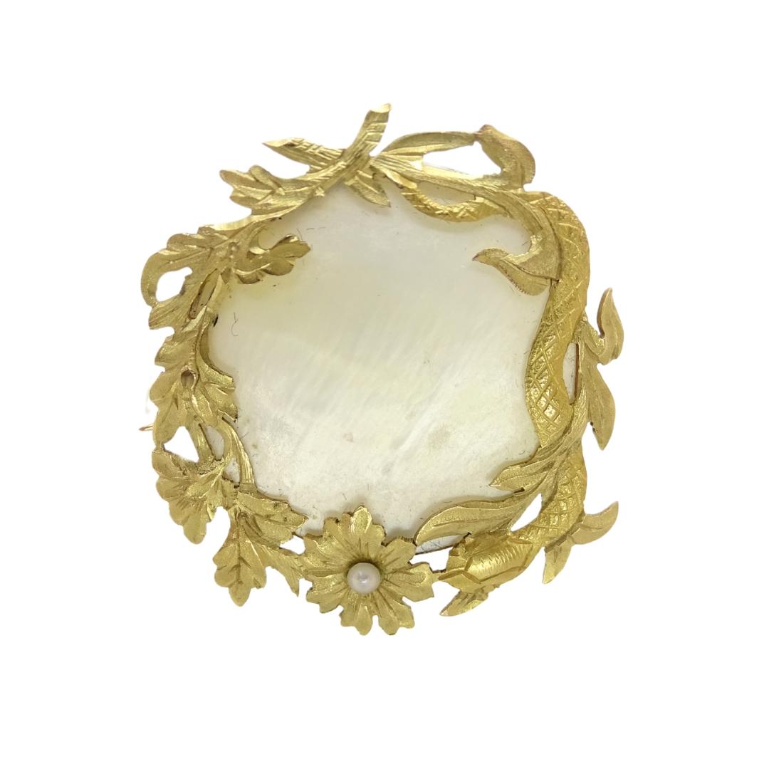 This brooch is an exquisite piece of jewelry that fuses classic elegance with a naturalistic and ornamental touch. Its gold structure features an organic design with intertwined floral and leaf motifs, typical of the Art Nouveau style, characterized