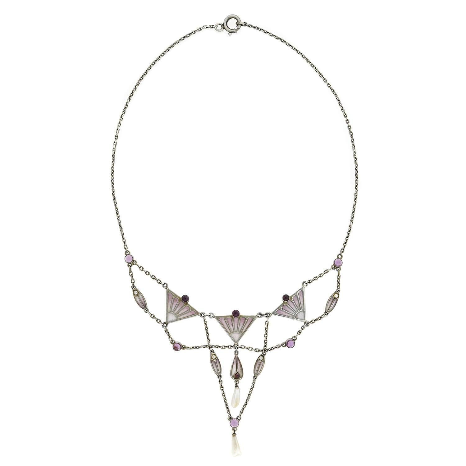 A breathtaking necklace from the Art Nouveau(ca1920s) era! Crafted in sterling silver, this necklace features wonderfully layered chains to create an intriguing design. Triangular frames house beautiful dusty lavender-colored plique-a-jour, enhanced