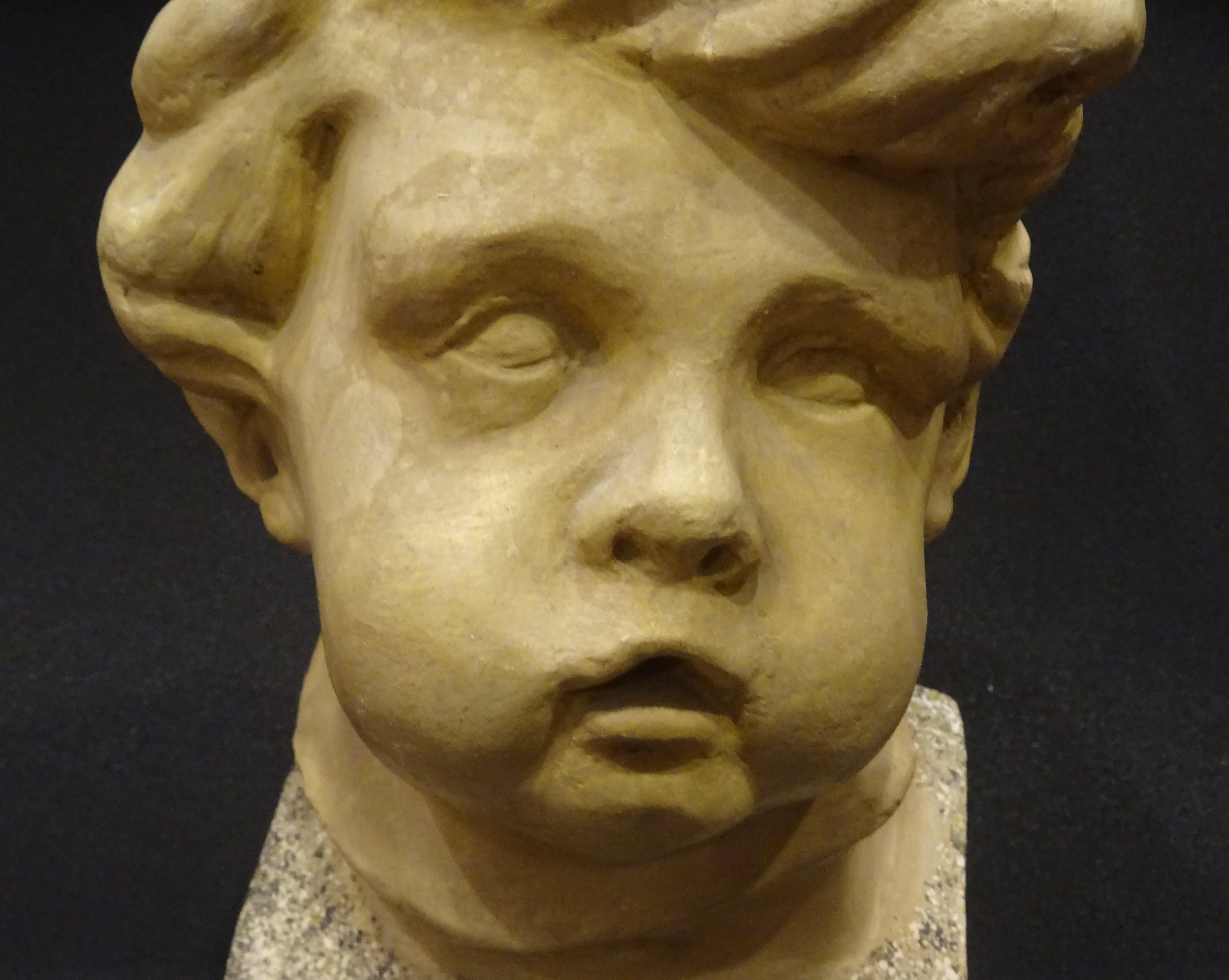 Early 20th Century Art Nouveau French School Plaster Carved Child Bust with Base Imitating Stone