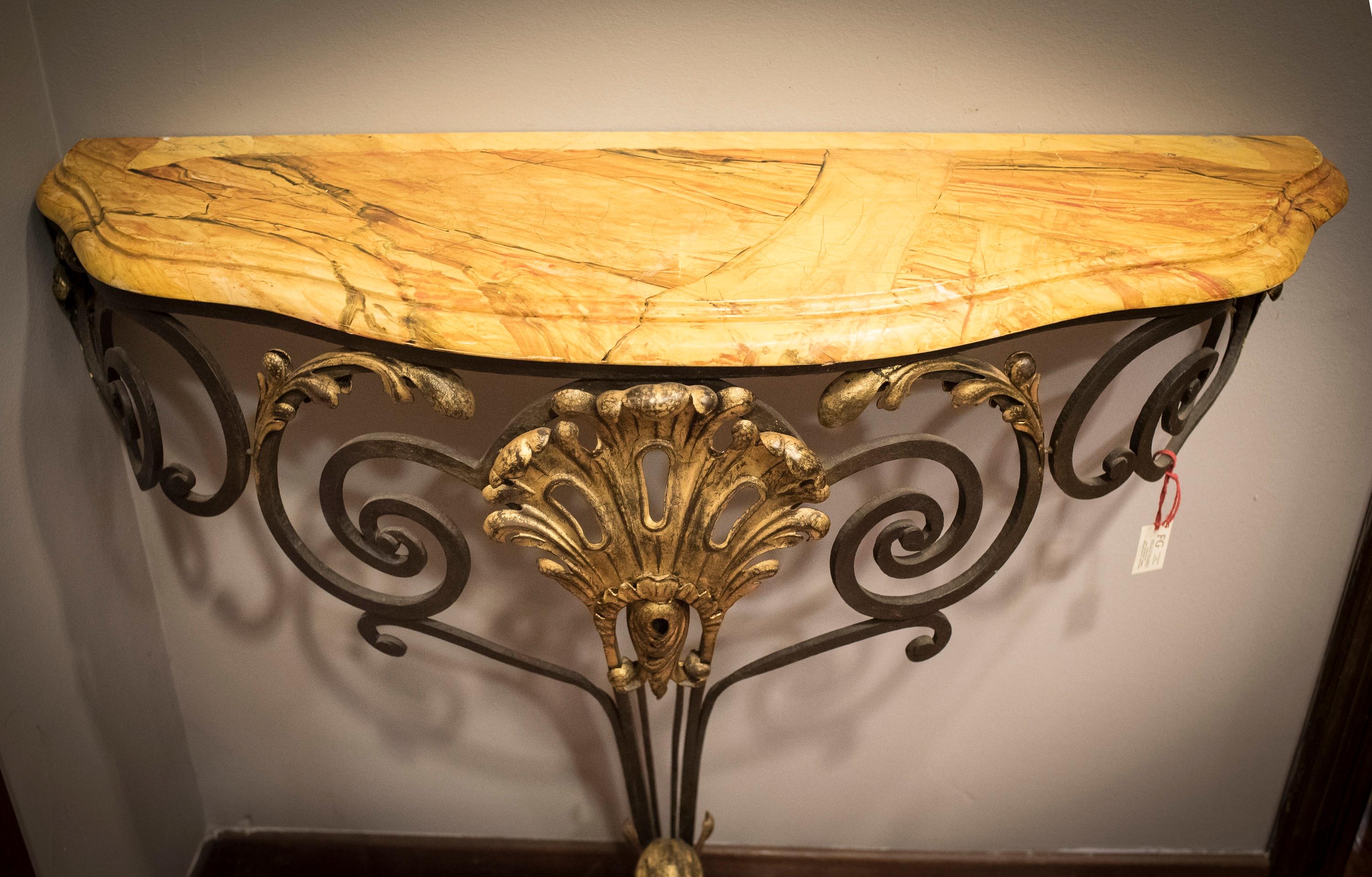 Awesome French wrought iron and yellow marbled wood top table, making a trompe l´oeil . With gold some places in the iron. A touch of timeless and fresh elegance.