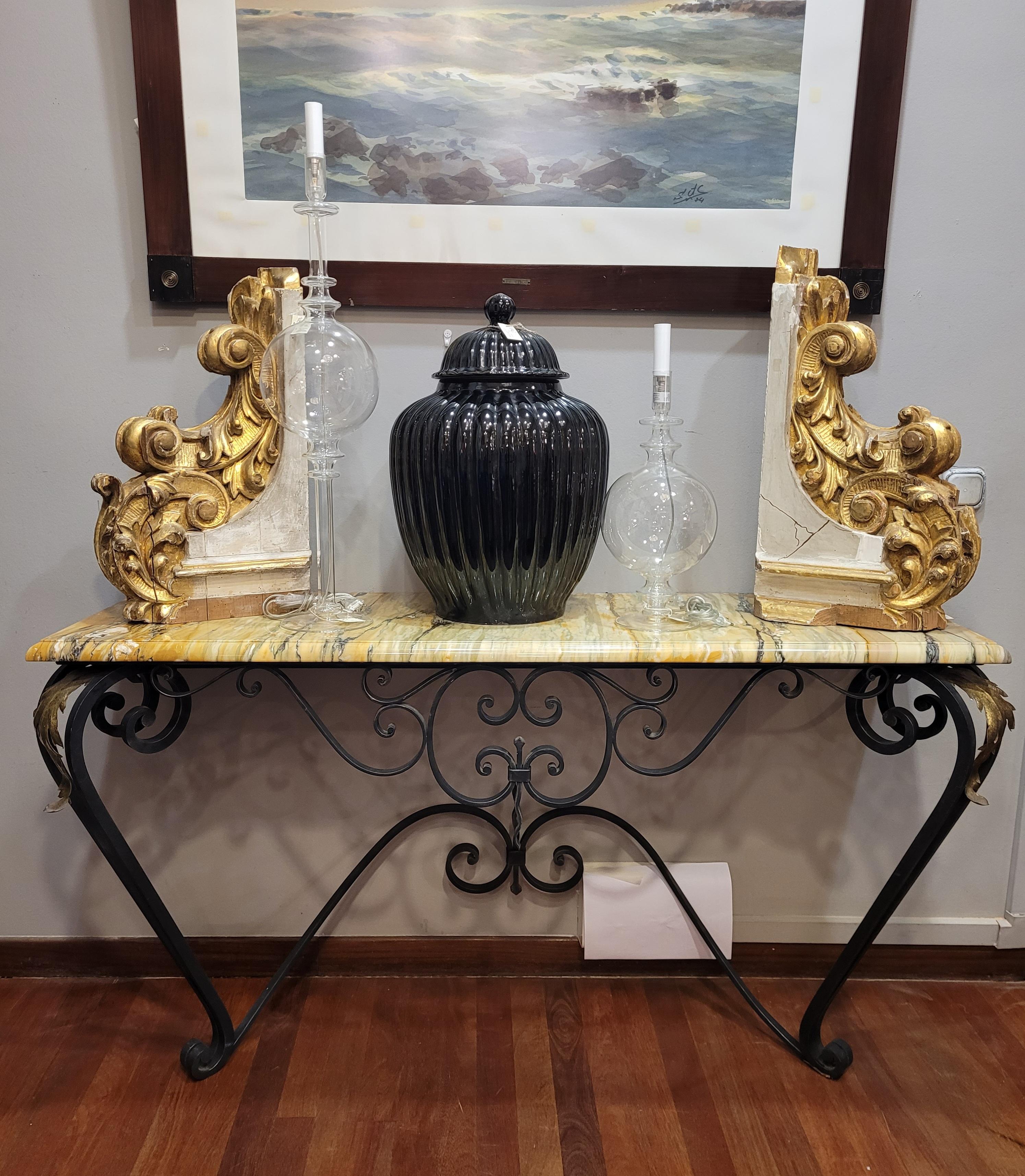 Outstanding Art Nouveau console with a rectangular profile with a wrought iron base and corner decoration with palm leaves in gold metal resting on two sinuous legs. Thick and bright Marble top with rounded profiles in a tone of soft green with