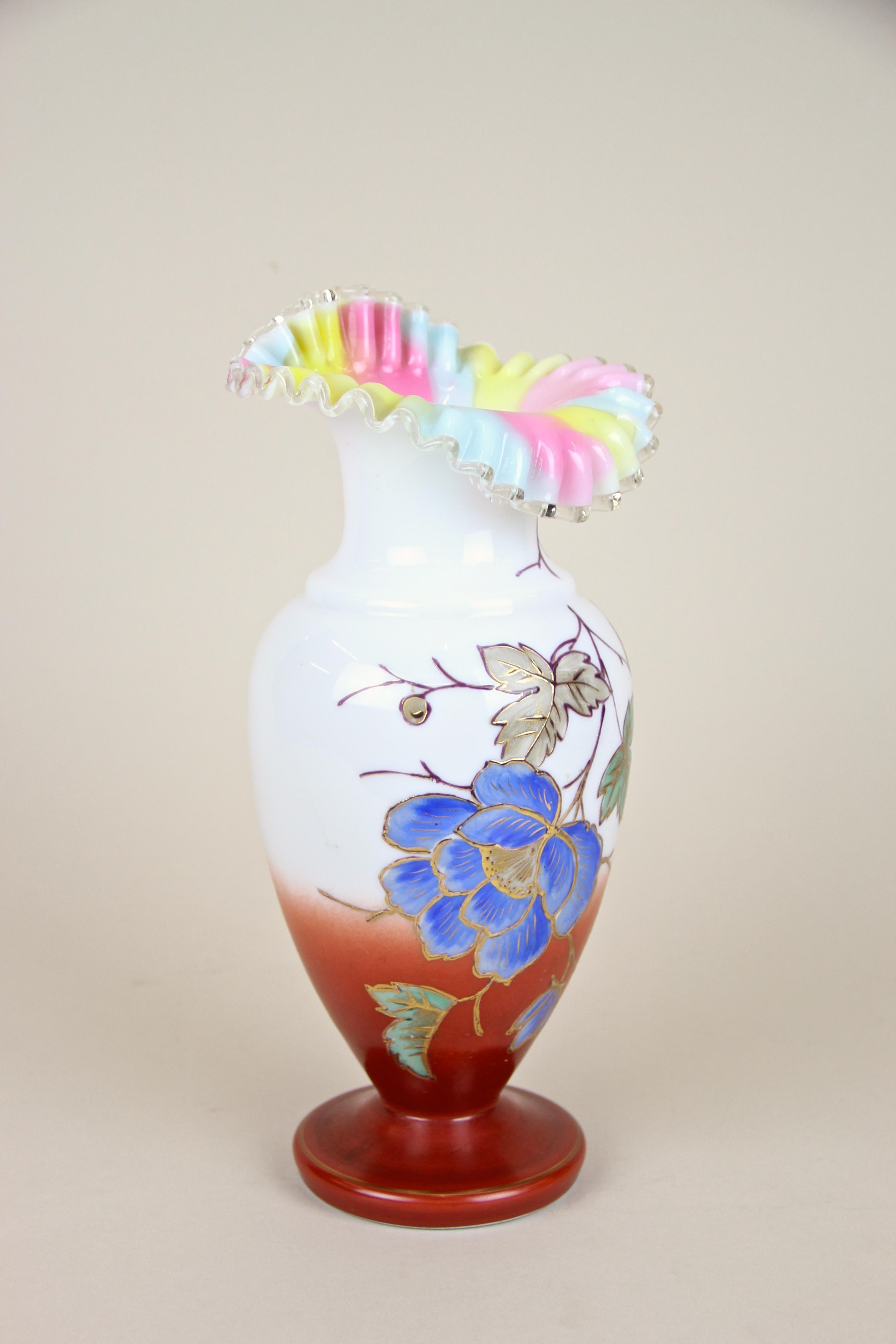 Out of the ordinary early 20th century glass vase with enamel paintings coming from Austria, circa 1900. The beautiful designed mouthblown white body with dark orange base is adorned by a big blue painted flower, leaves and golden accents and shows