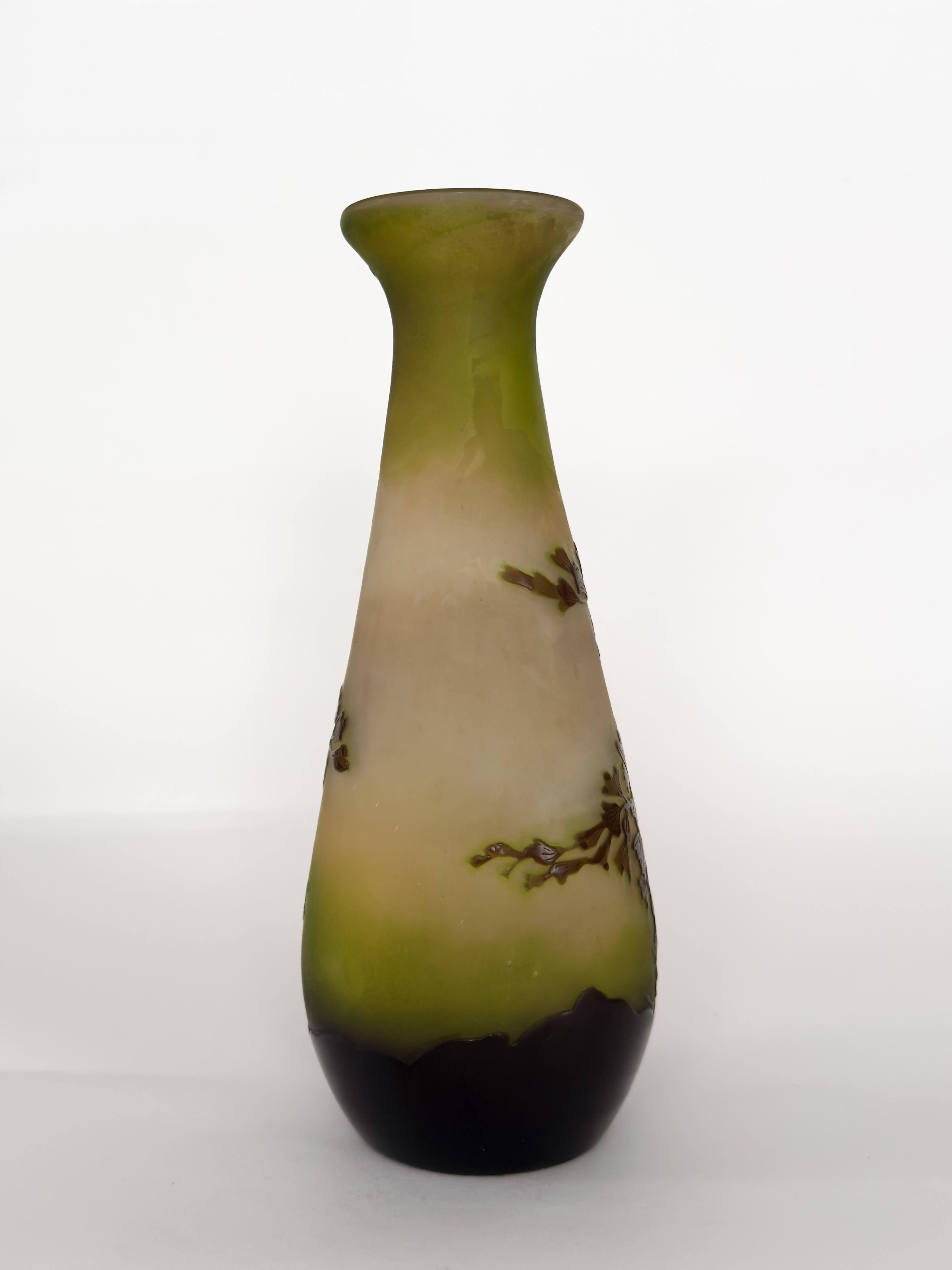 Este jarrón de vidrio Art Nouveau de Émile Gallé presenta motivos botánicos, elaborados en vidrio camafeo estratificado.
El jarrón presenta un degradado que va desde un verde intenso y entintado en la base hasta un delicado verde claro en la parte