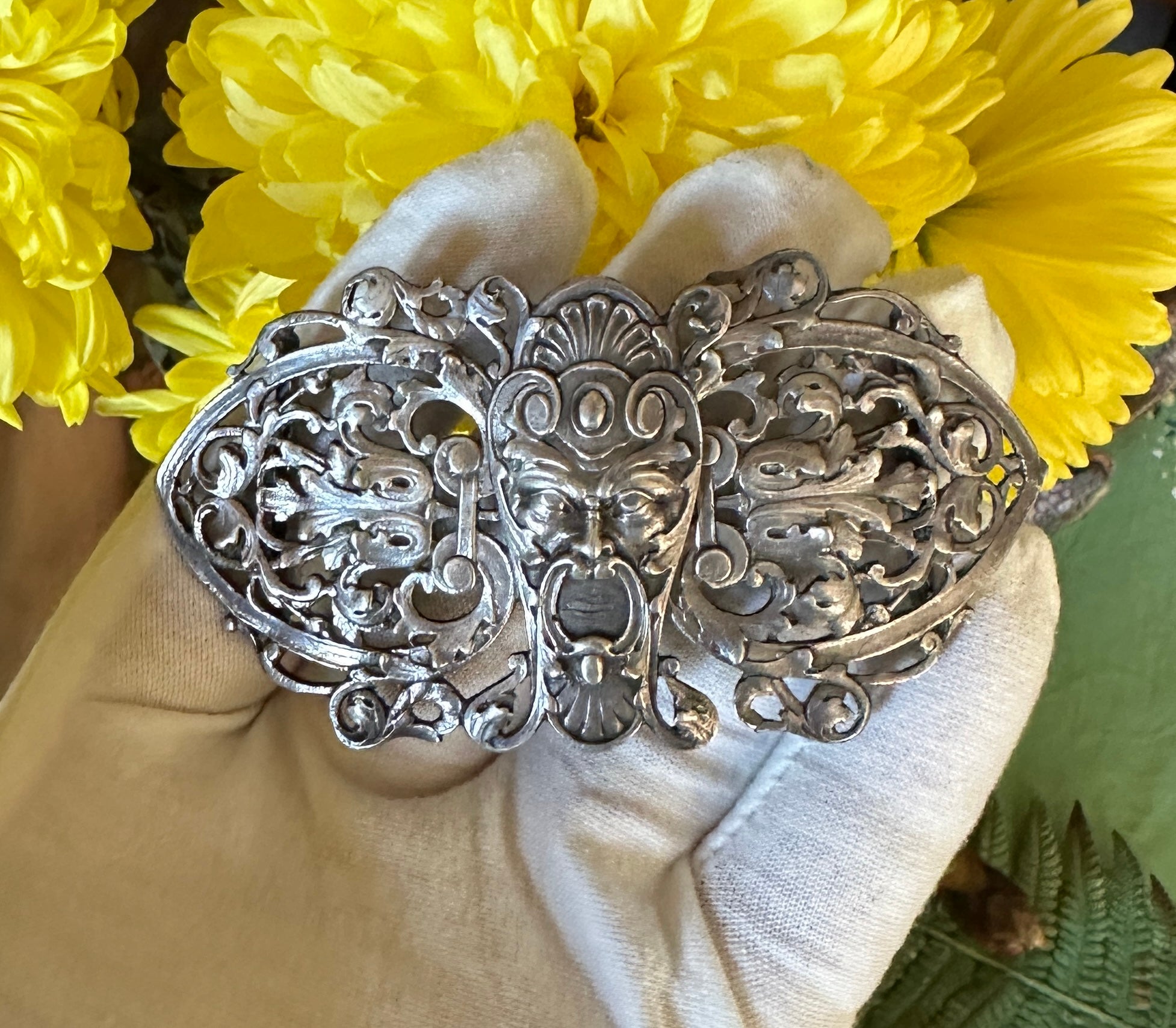 This is a stunning and rare antique Belle Epoque Buckle in Sterling Silver with a Gargoyle, God or Grotesque Imagery with acanthus leaf designs throughout.  The Gargoyle face is surrounded by open work foliate acanthus motifs.   The very unusual and