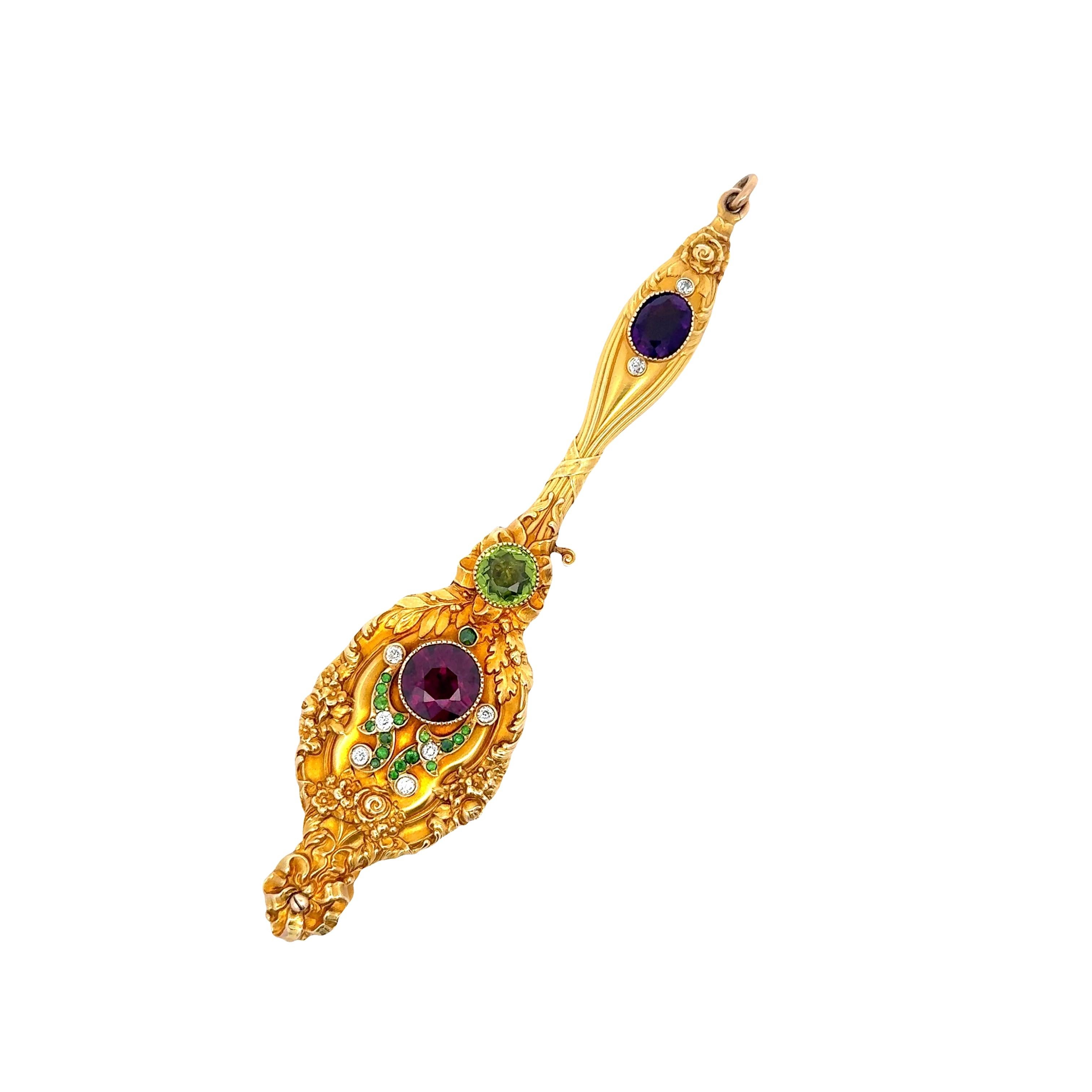 A striking pendant featuring approximately 5.00-carat round garnet as its focal point, radiating a deep red hue. Complementing the garnet is an amethyst, displaying a rich purple color. The piece is adorned with additional stones, including