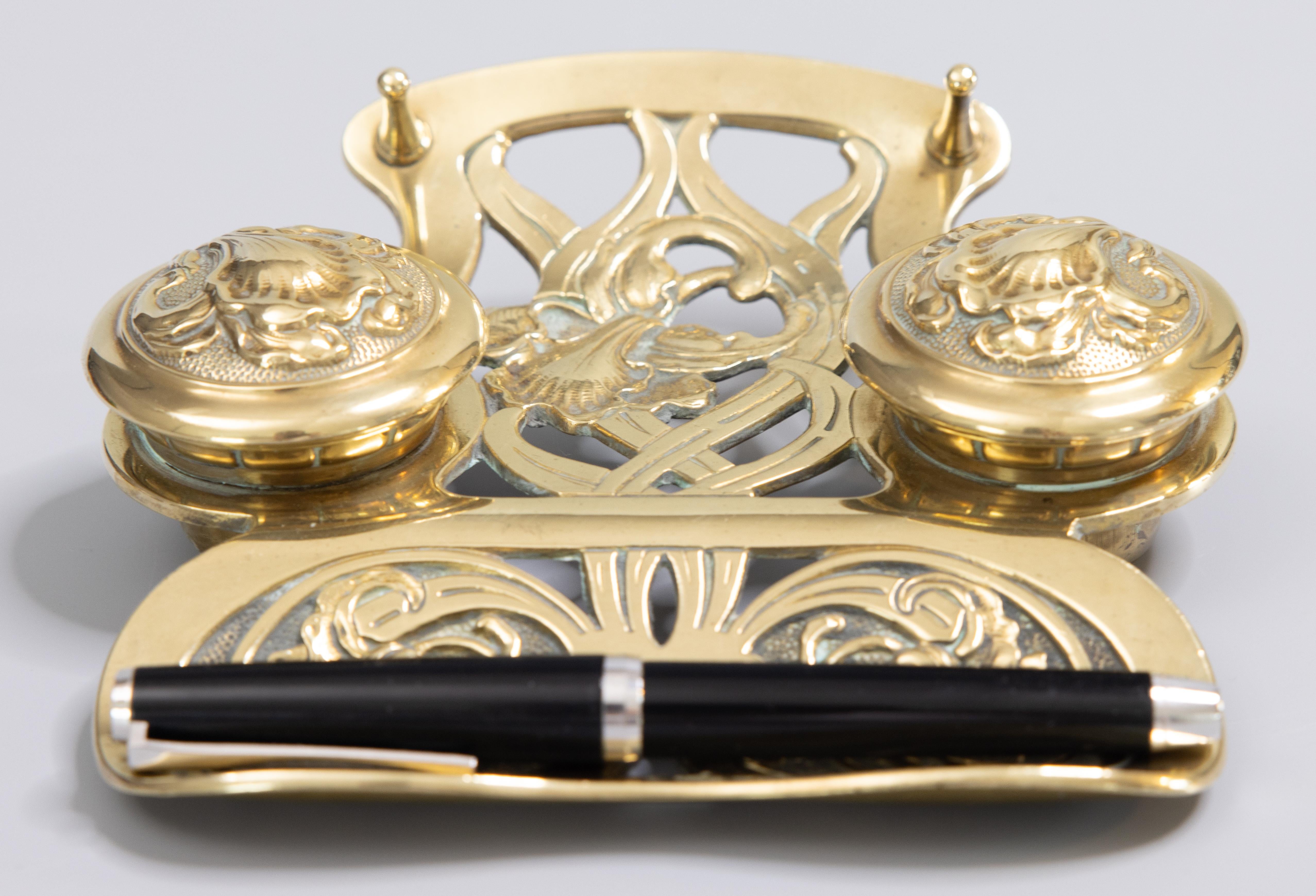 A superb antique Art Nouveau Jugendstil German cast brass double inkwell inkstand with a pen rest and pen tray, circa 1900. The base is stamped 