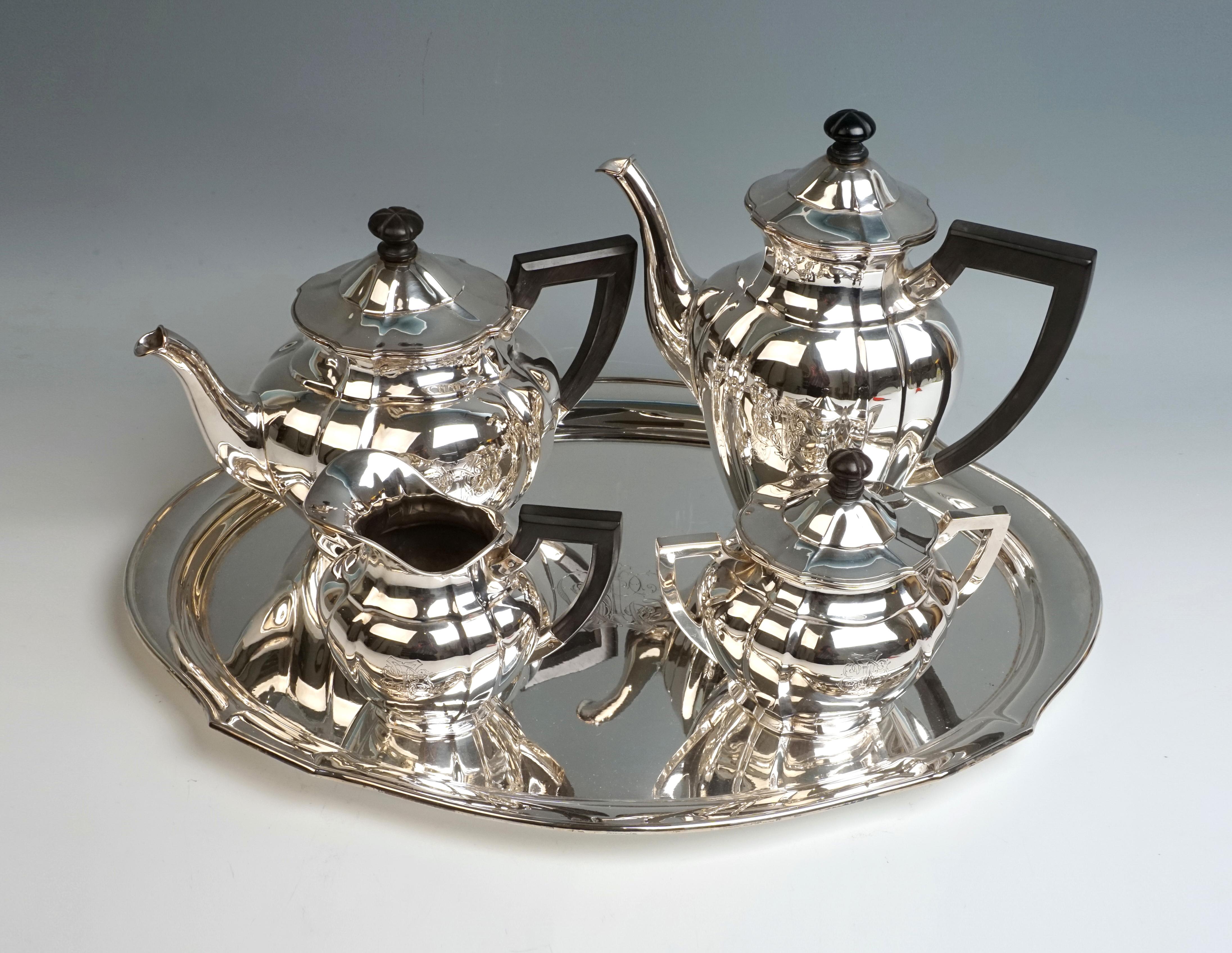 Elegant 5-piece silver centerpiece consisting of coffee and teapot, milk jug, sugar bowl and tray. Oval basic shape, bulging wall of the vessel body, vertically divided by pilaster-like folds. Coffee and teapot with swan spout and hinged covers with