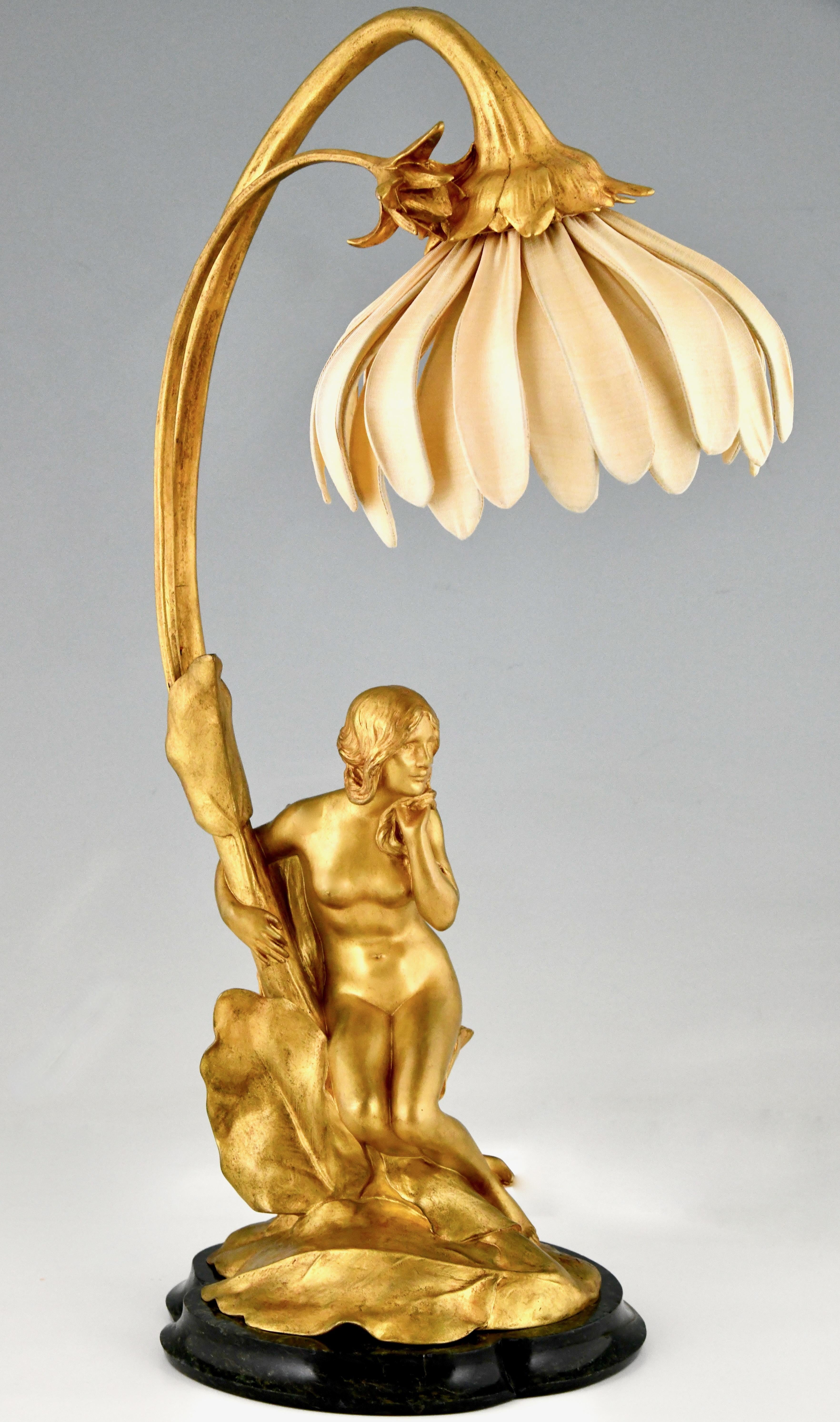 Art Nouveau gilt bronze lamp with nude by Maurice Bouval, France 1906.
With the foundry seal of Jollet & Cie, Colin.
Gilt bronze on a marble base with a silk shade in the shape of a flower. 
This model is illustrated in
Dynamic Beauty, Macklowe
