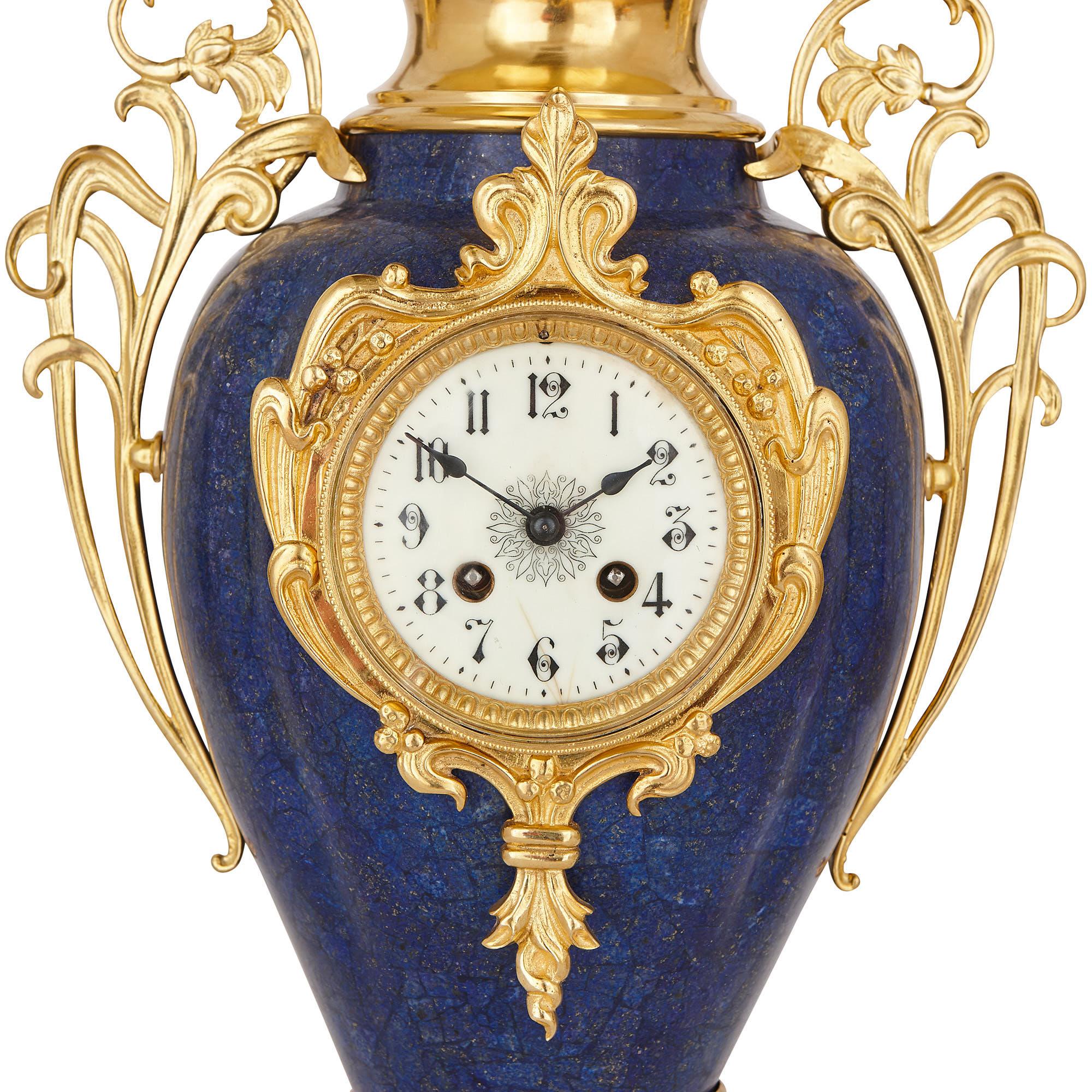 This clock set is designed in the Art Nouveau style, which was popular in France in the early 20th century. The set is comprised of a tall central clock and two slightly smaller flanking vases. The items have been crafted from gilt bronze, and more