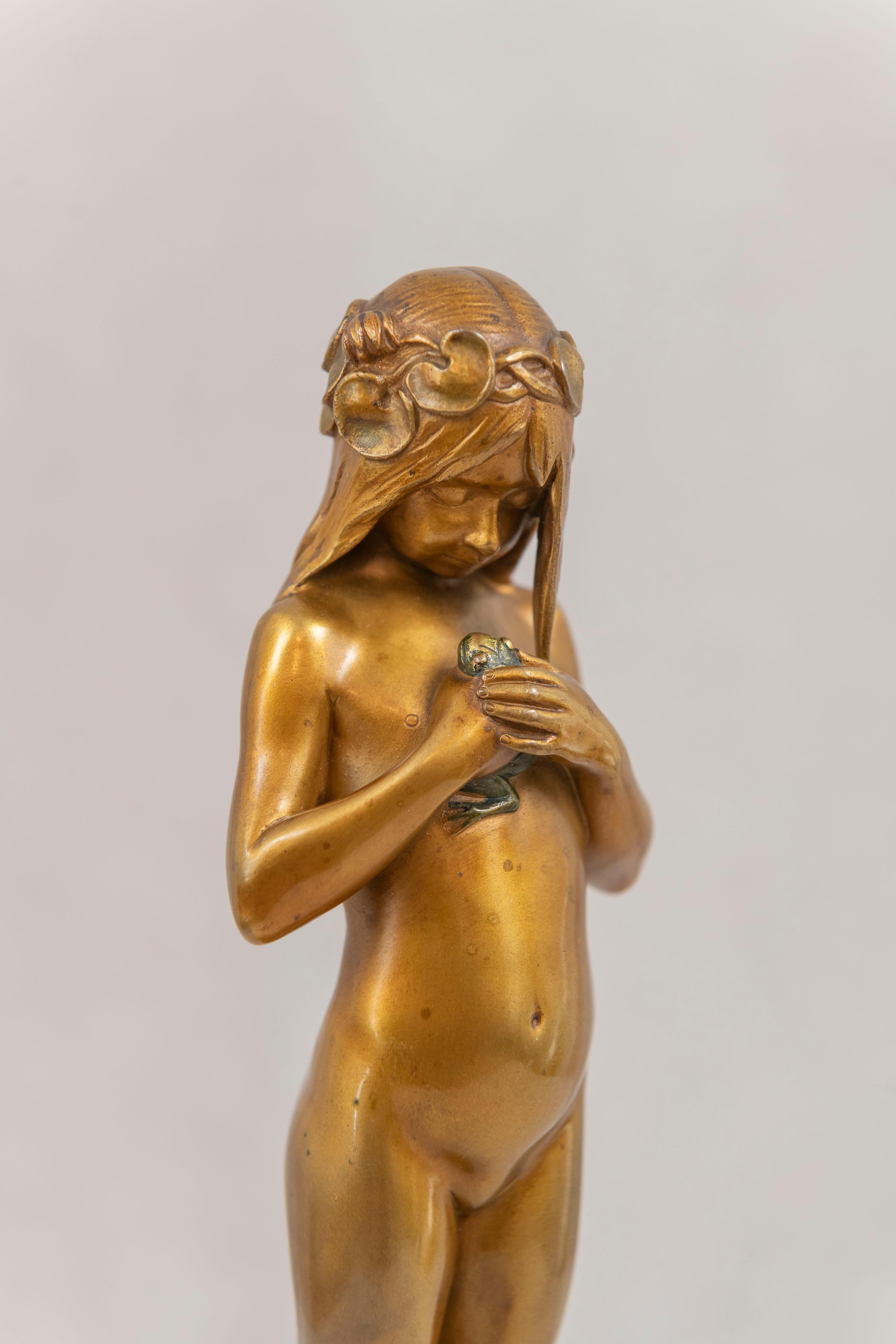 This beautiful little nude girl holding her pet frog is a joy to the eye and to the touch. Having her hair wrapped in flowers is a nice art nouveau touch. The gold patina is exceptional and brings her to life. The frog just adds to the mystique of