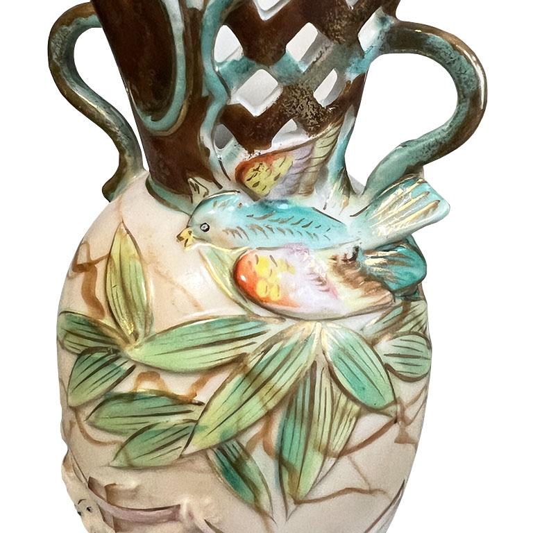Un grazioso vaso in ceramica art déco con motivo di cherubini e uccelli. Questo piccolo pezzo è di UCAGCO ed è stato creato nel Giappone occupato. È realizzato in ceramica e presenta una maniglia dorata su entrambi i lati del bordo superiore. La