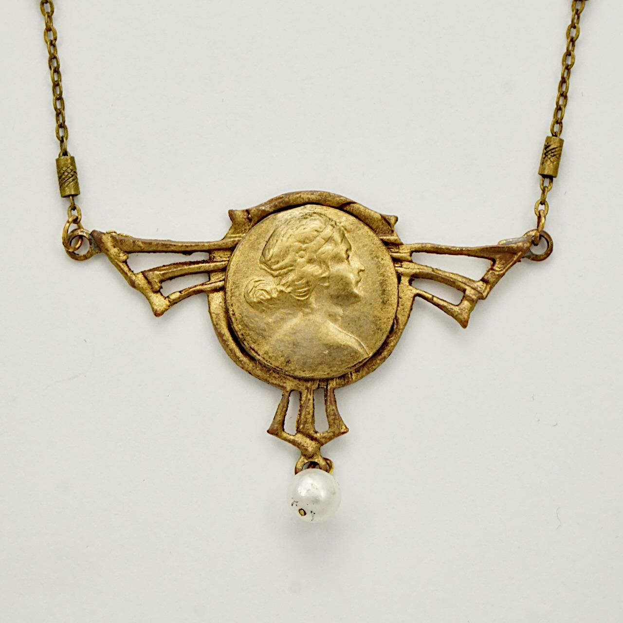 Lovely Art Nouveau gilt metal lady pendant with a cultured pearl drop, and fancy link chain. The necklace measures length 57 cm / 22.4 inches. There is wear to the gilt.

This is a beautiful Art Nouveau pendant and chain.