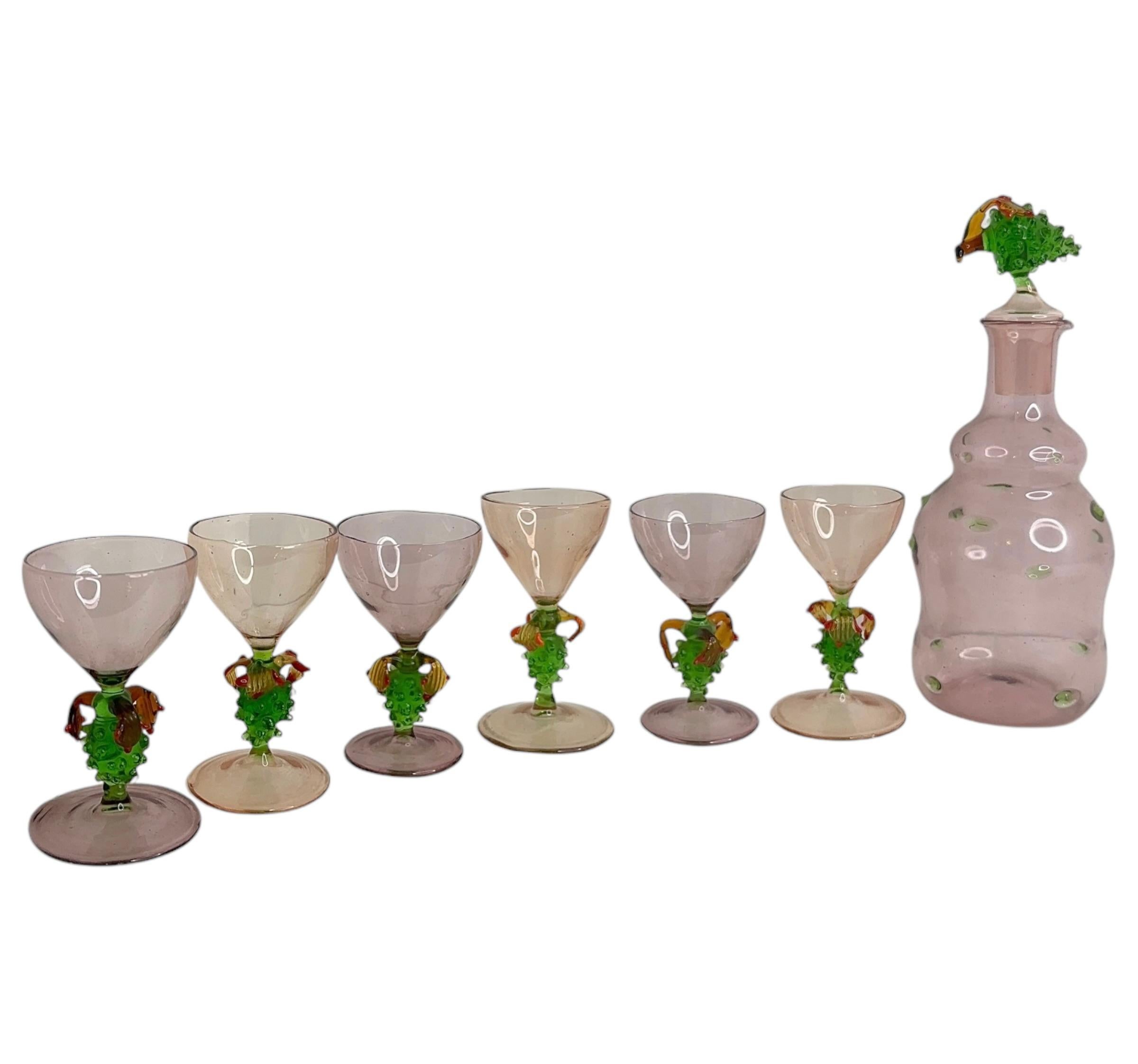Un juego de decantador Art Nouveau ligeramente descarado con un juego a juego de seis vasos de cristal transparente soplado a mano, al estilo de Bimini. Los tallos diseñados como uvas. En bonitos colores pastel. Muy delicado al tacto y sorprendente