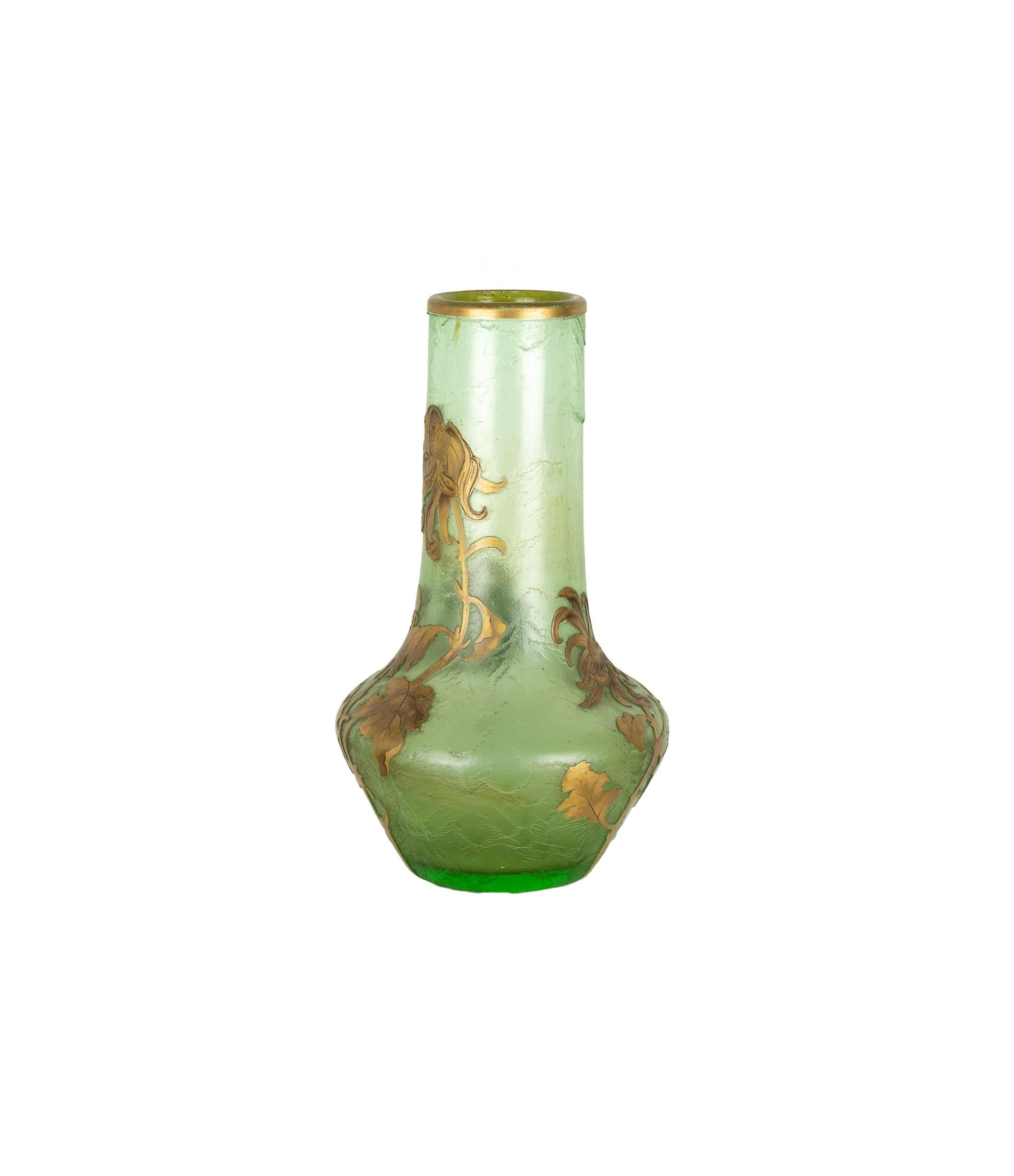 An early 20th-century Art Nouveau glass vase, by Montjoye, France. 
This vase features a soft translucent green hue and adorned with delicately gilded floral motifs. 
The surface has a subtle textured finish, enhancing the organic flow of the golden
