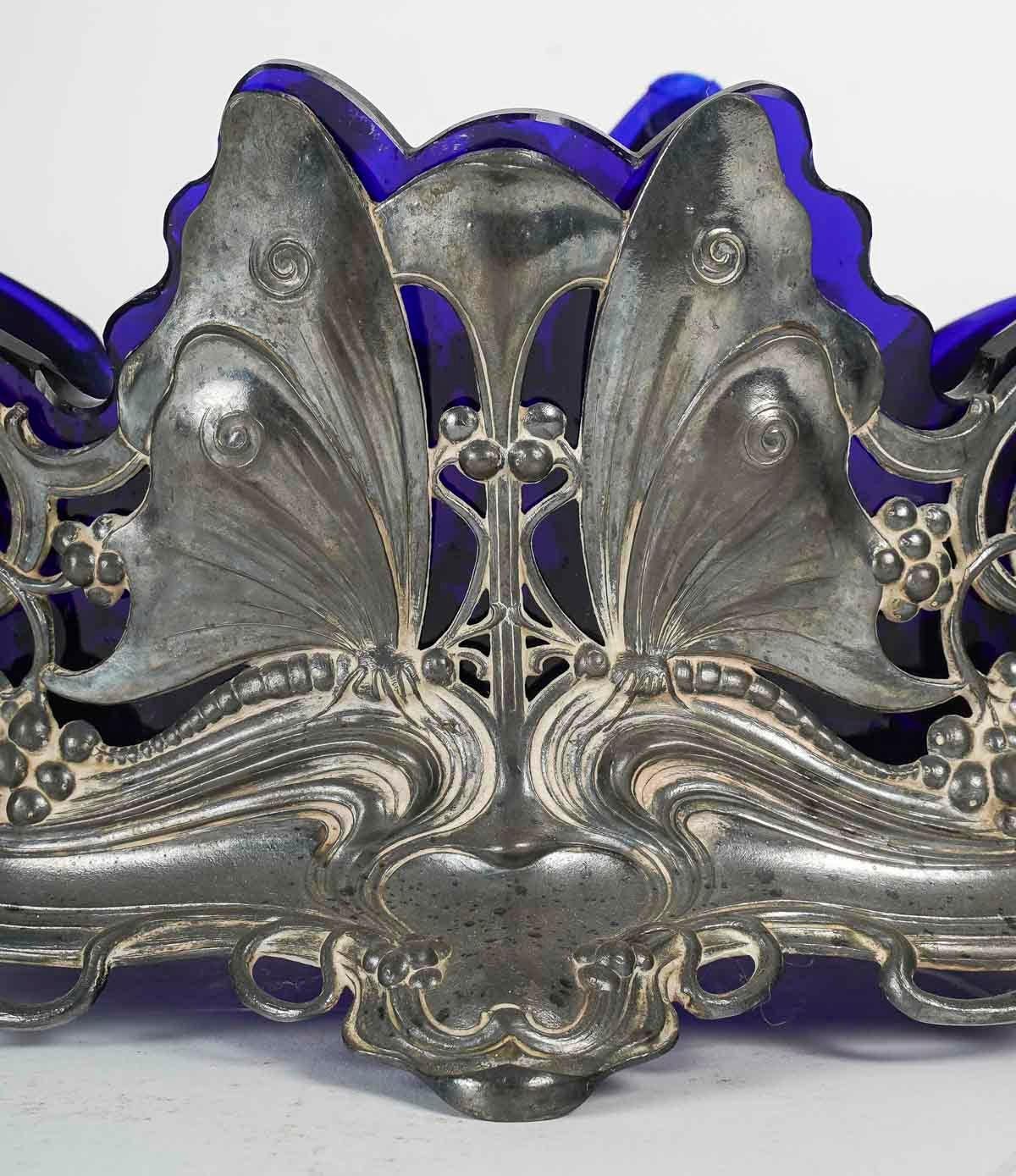 Art Nouveau goblet, Circa 1900, Floral and butterfly design.

An Art Nouveau pewter and blue crystal bowl with butterfly and floral decorations, Circa 1900.
h: 20cm, w: 40cm, d: 18cm