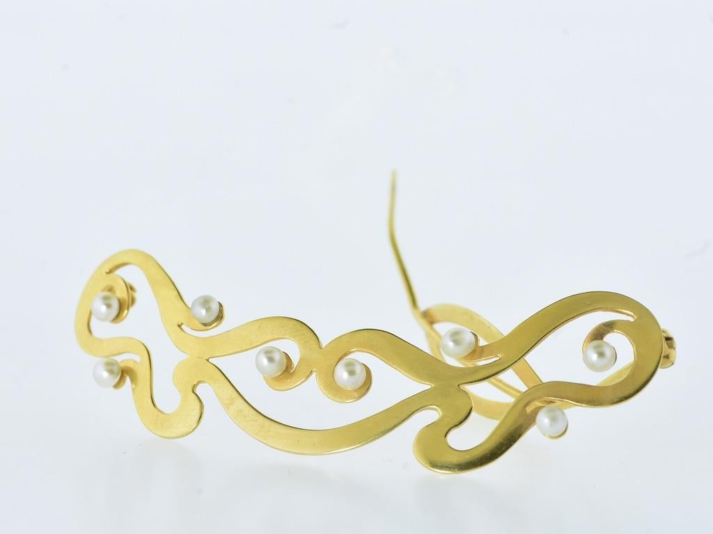 Art Nouveau gold barrette with 8 fine, well matched, round natural oriental pearls with fine luster.  This antique hair barrette measures slightly less than 2 7/8th inches across.  It is made well and in good condition. The locking clasp is marked