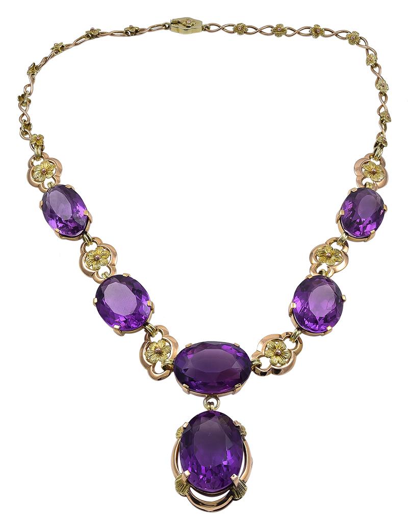 Regal Art Nouveau necklace.  14K yellow gold, set with approximately 75.00 carats of brilliant faceted amethysts.  Rich deep purple color.  Lovely link chain with applied fleurettes.  16