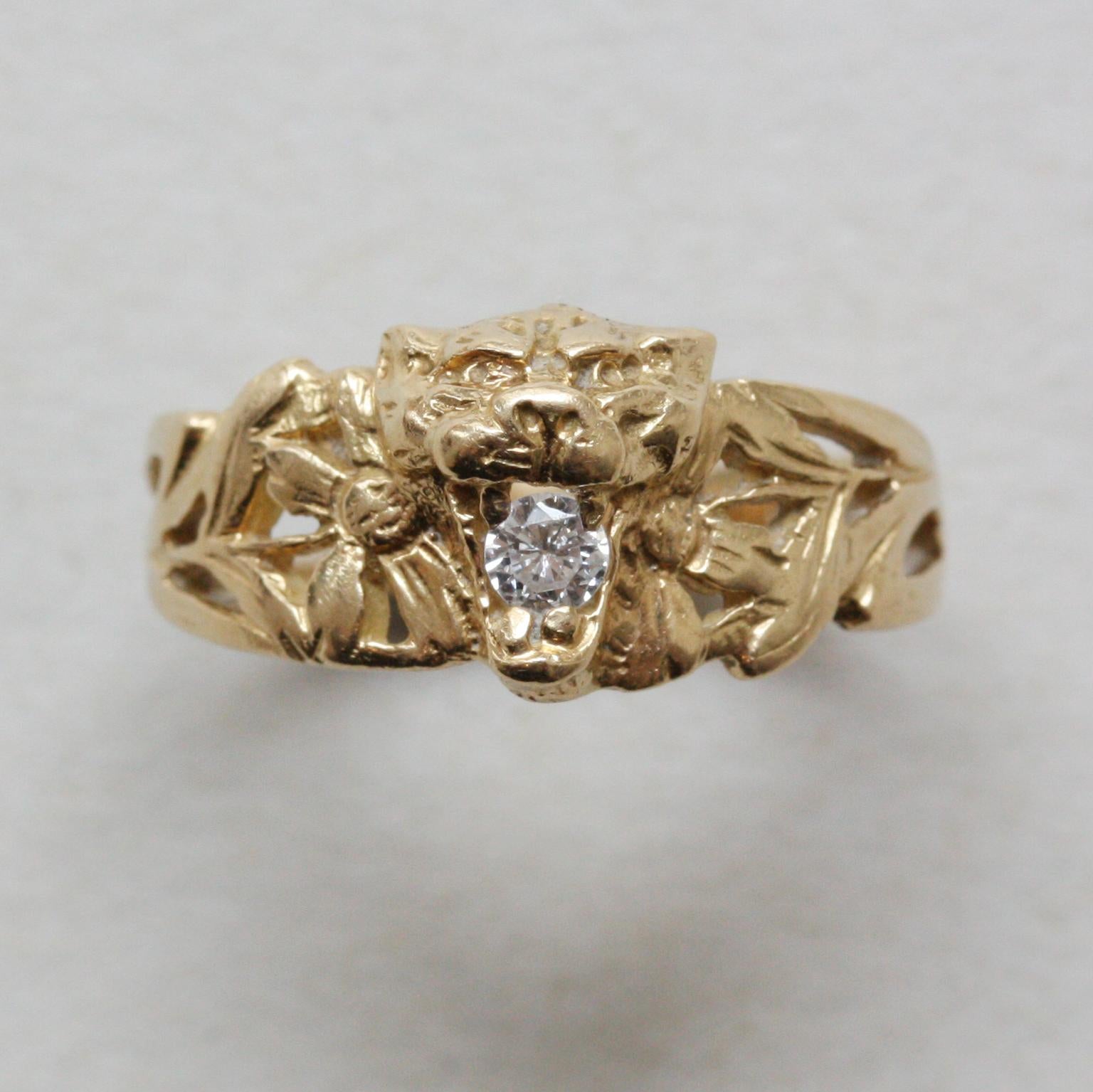 An 18 carat gold Art Nouveau ring with a lions head holding a diamond in its mouth on each side and the shank are decorated with flowers, circa 1900, French with master mark.

ring size: 16 mm