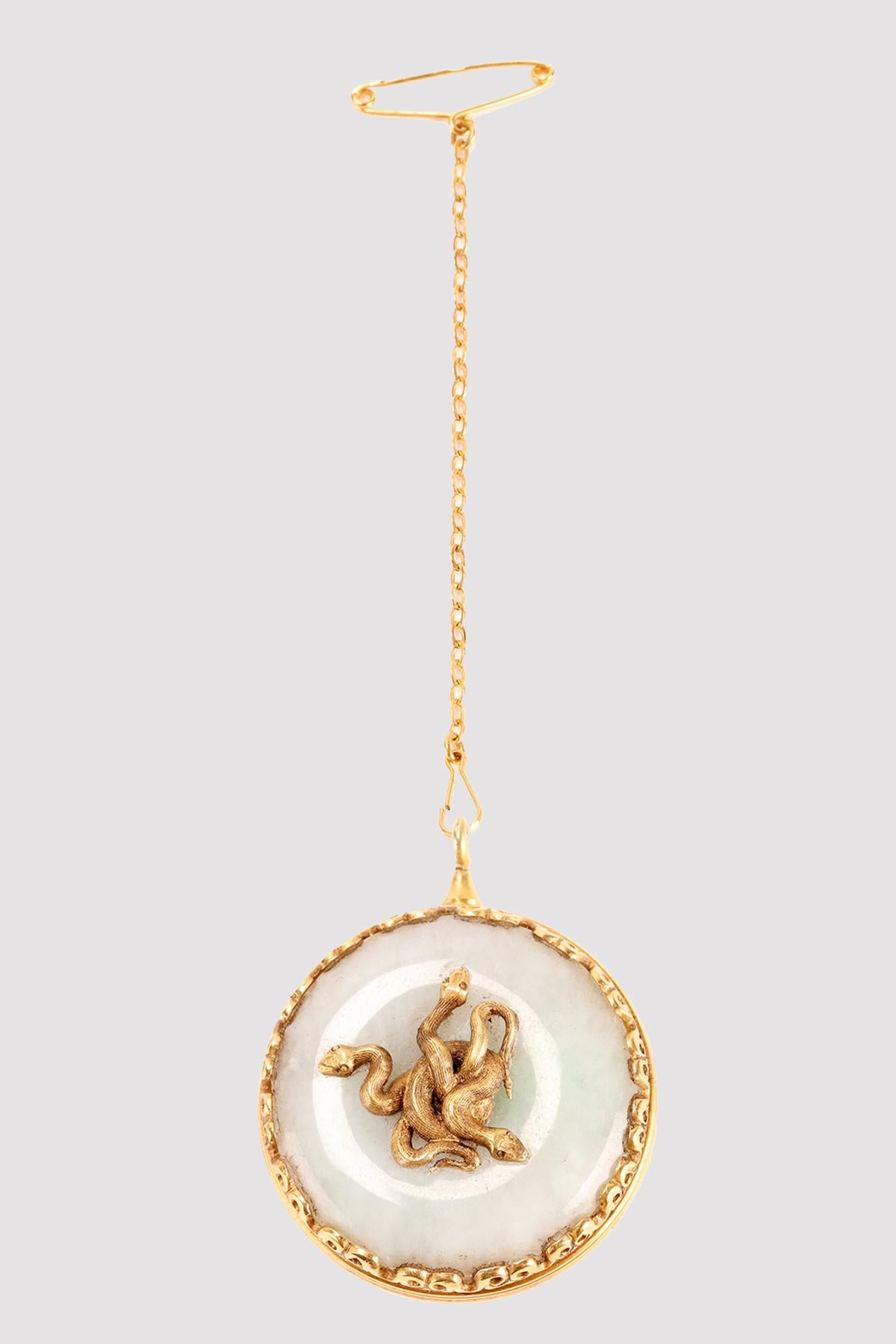 Round Art nouveau Vinaigrette, made of 18K gold. Configured as a pendant with safety lock.The lid of the box is in white jade with in the center several coiled snakes that also invade the inside of the lid. Marks: eagle head and goldsmith's mark