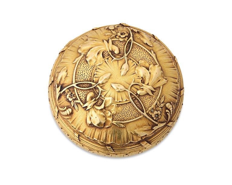 This exquisite French gold compact created by the famed jewelry house Boucheron is a work of outstanding artistry. Both practical and striking, this piece embodies the fashionable Art Nouveau style, with flourishes and blooms forming a stunning