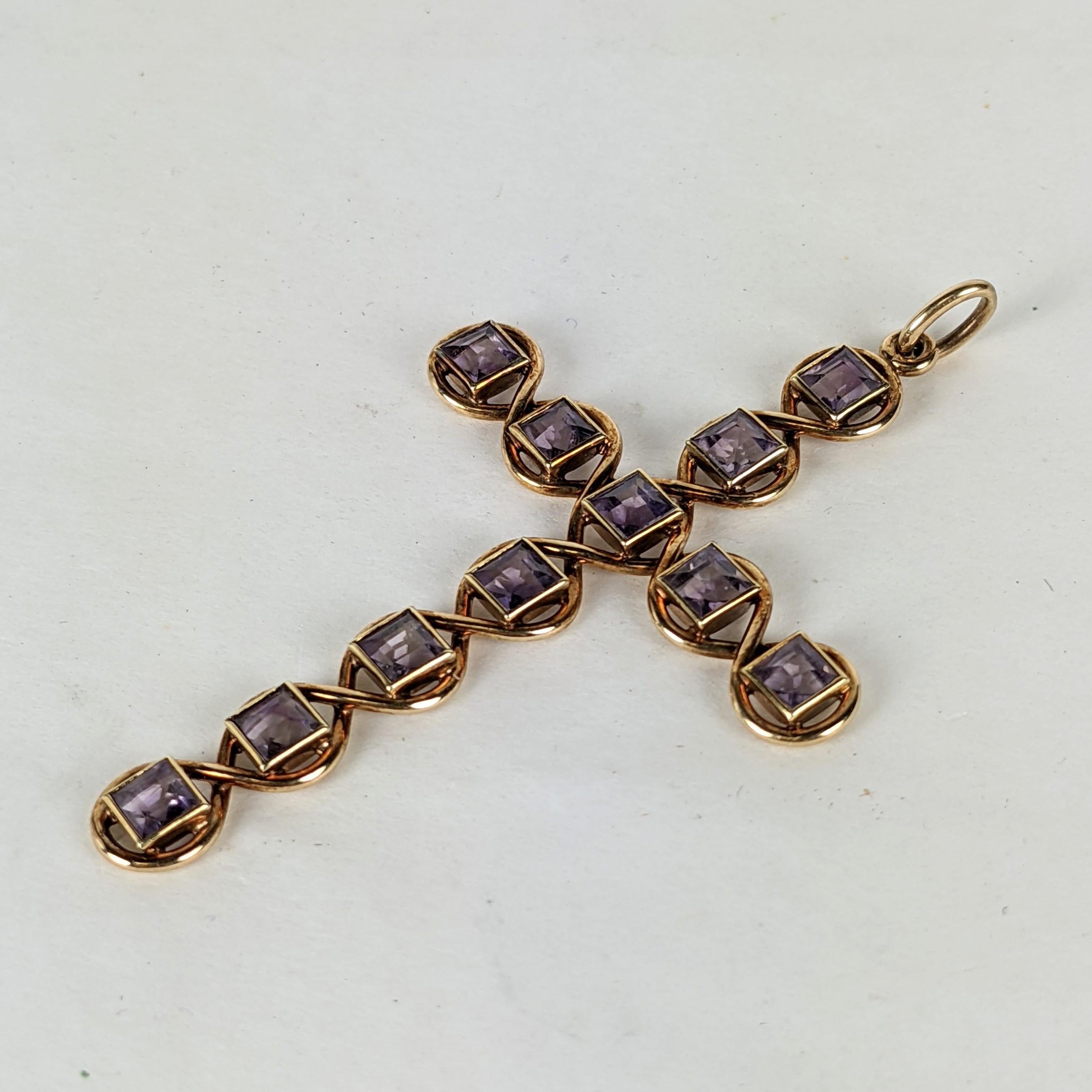 Elegant Art Nouveau Gold Cross handcrafted in 14k gold from the early 20th Century. Square cut purple stones are likely amythests or pastes. The stones are set in a 14k gold wire frame which wraps around each stone in a continuous fashion.  1900