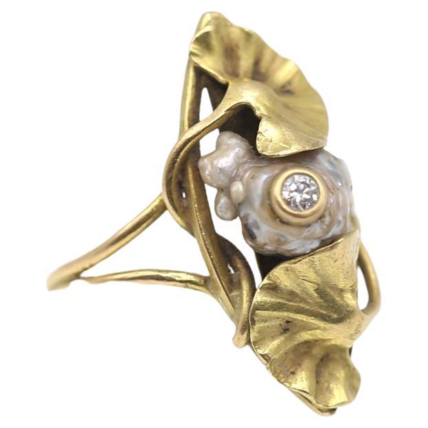 Art Nouveau Gold Diamond Pearl Ring.
Exceptionally delicate ring representing a pinnacle of the Art Nouveau style, both in terms of materials and design. Two amazingly crafted water lily leaves are holding a beautiful natural pearl of a mystic