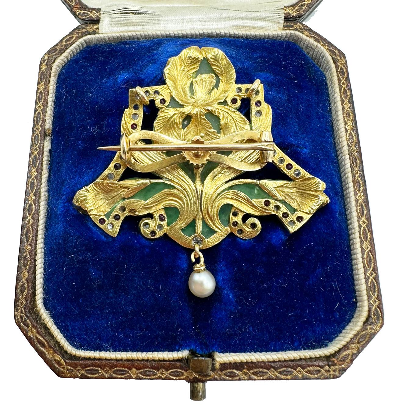 Dessiné comme un iris en émail polychrome et perles de rocaille, avec feuilles d'or gravées et cadre en cartouche orné de diamants taillés en rose et de rubis taillés en cercle, serti sur une belle couleur verte translucide, se terminant par une