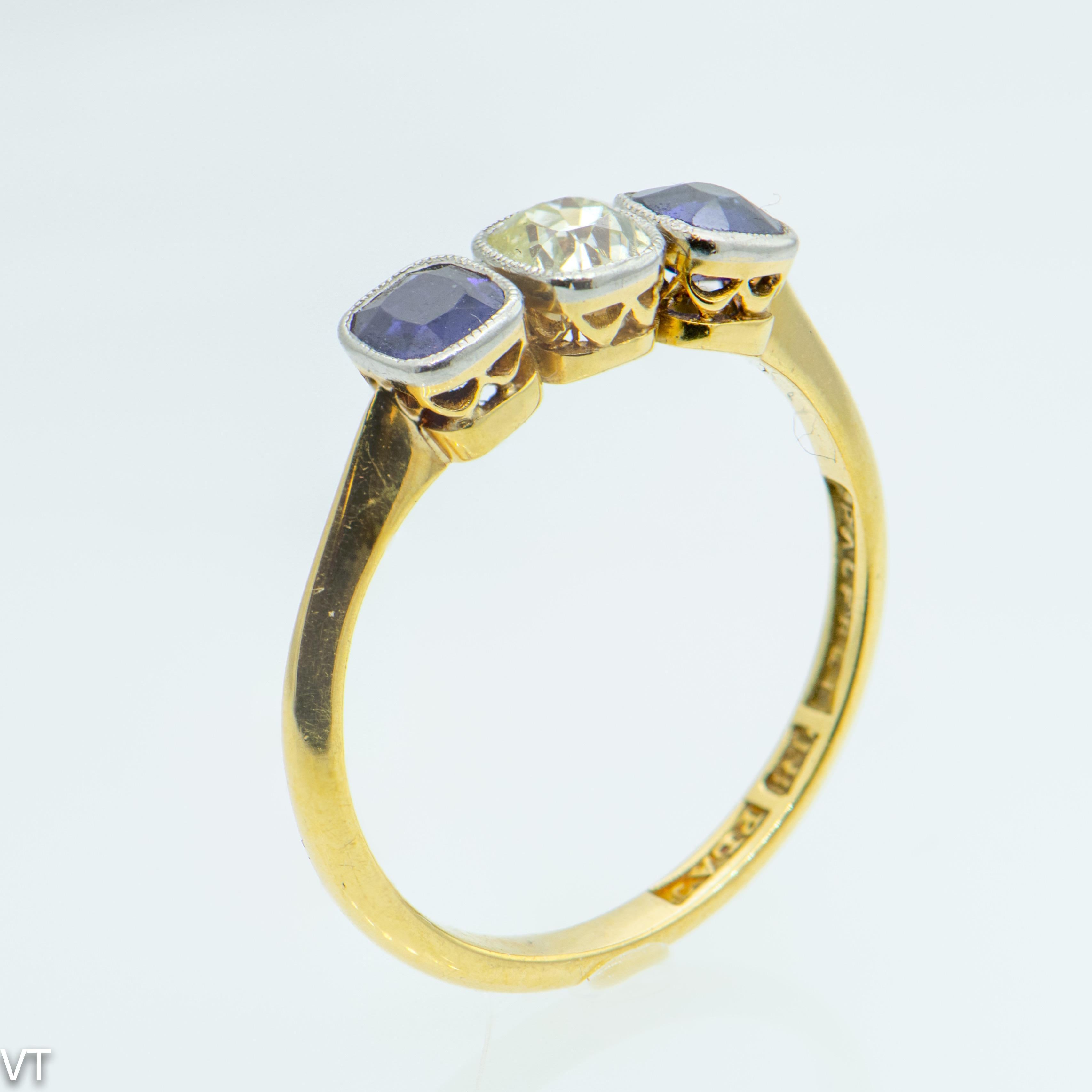 Art nouveau 18 carat Yellow gold ring with one cushion old-cut Diamond, estimated 0.45 carats
and two cushion old-cut Australian Sapphires, total estimated 0.90 carats.
Stones are set in platinum setting.
Size N (US size 6 3/4),
Weight of the ring