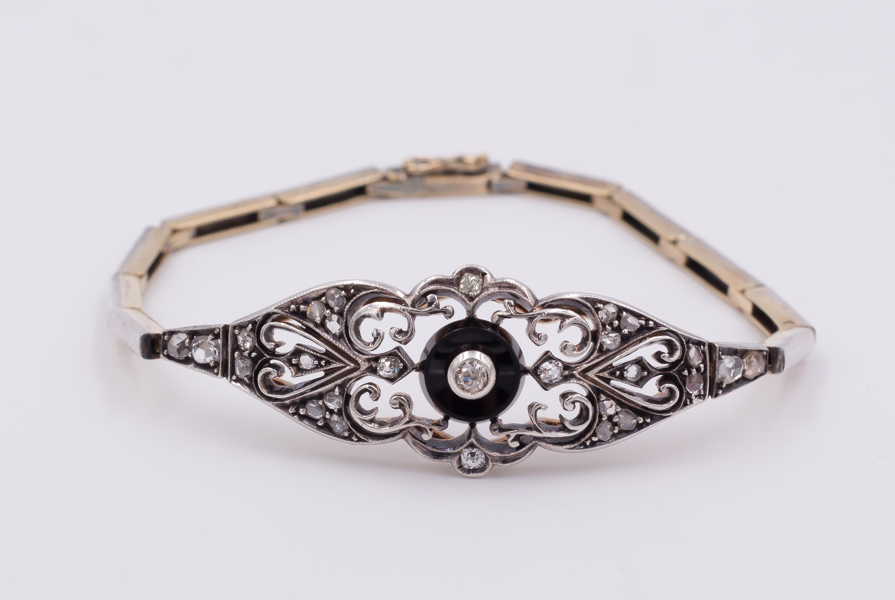 This stunning Art Nouveau jewel features a gold and silver chain, with a central beautiful decoration, set with rose cut diamonds, an onyx disk and openworked details. 
This jewel is three jewels in one. It can indeed be a necklace, but also two