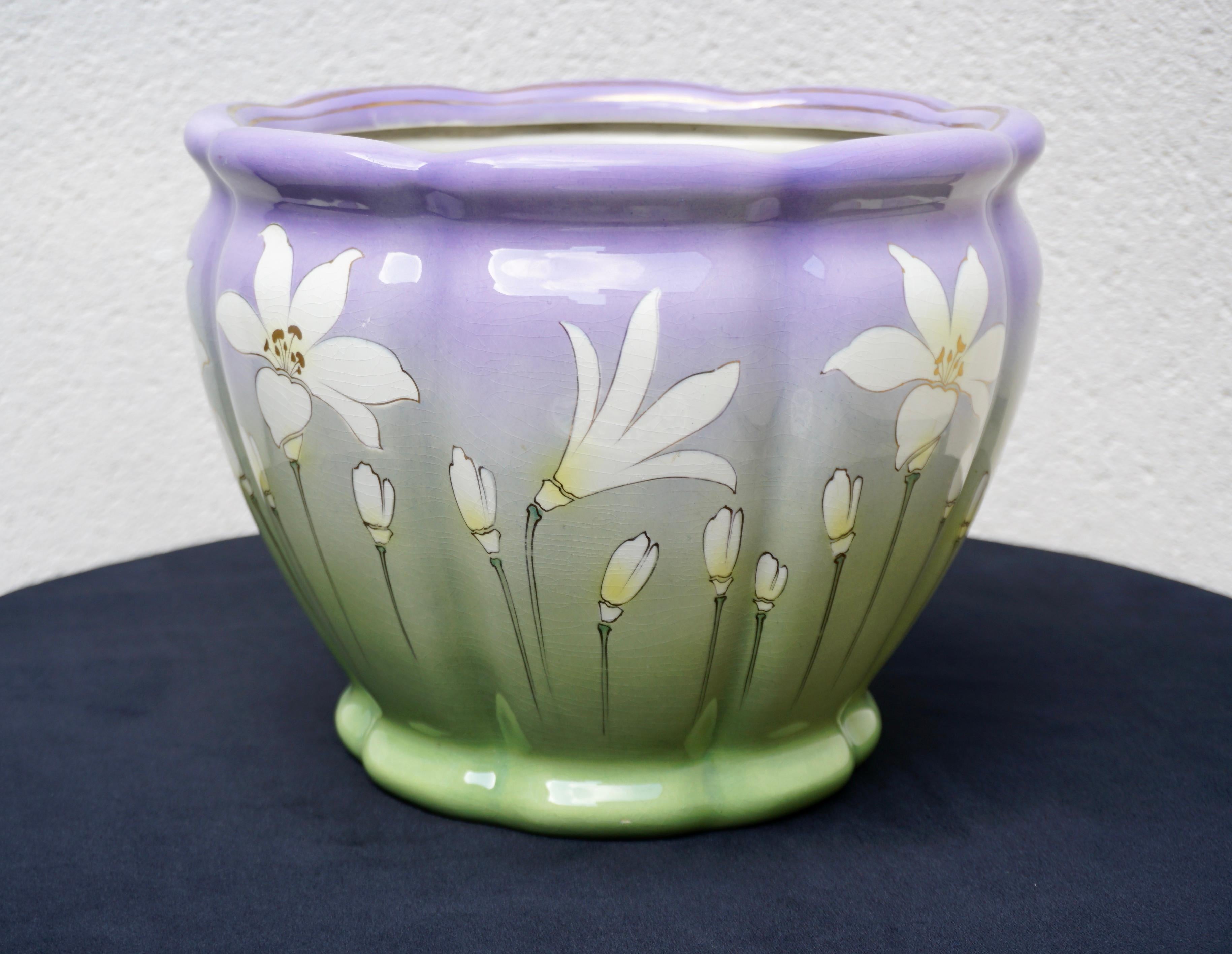 An France ceramic purple lilac and green flower or plant pot holder cachepot jardiniere planter with white flowers, circa early-20th century, France. Great as a standalone piece or to add with other planters' cachepots. 
  
Dimensions: 711.4