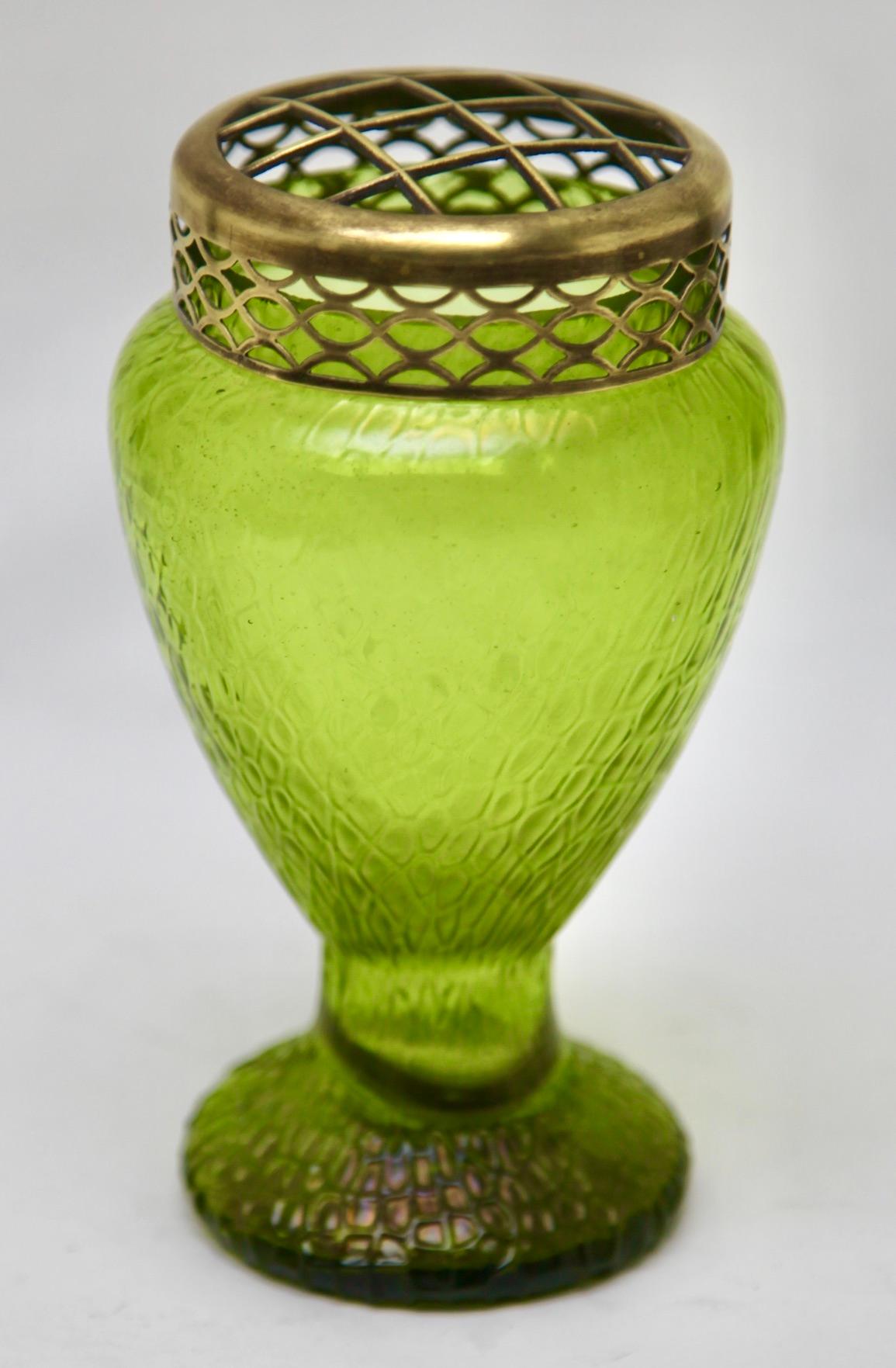 Art Nouveau Green iridescent glass Pique Fleurs' vase by Loetz' with Grille

Subtle, hand blown glass vase in the Art Deco style. This design for vases is often called 'Pique fleurs' or 'rose-bowl' and is supplied with a fitted metal grille to