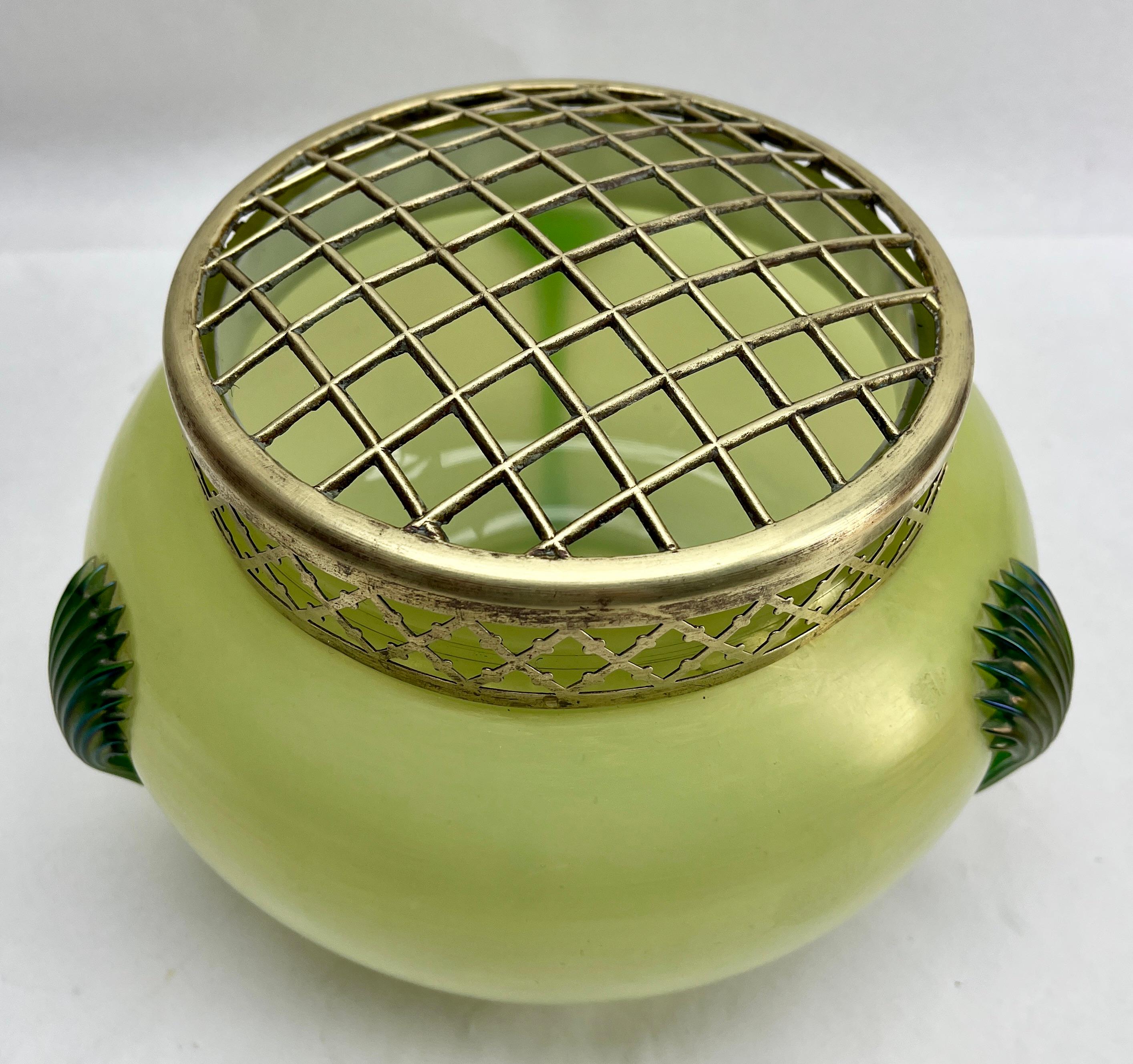 Art Nouveau Large Green iridescent glass Pique Fleurs' vase by Loetz' with Grille

Subtle, hand blown glass vase in the Art Deco style. This design for vases is often called 'Pique fleurs' or 'rose-bowl' and is supplied with a fitted metal grille to