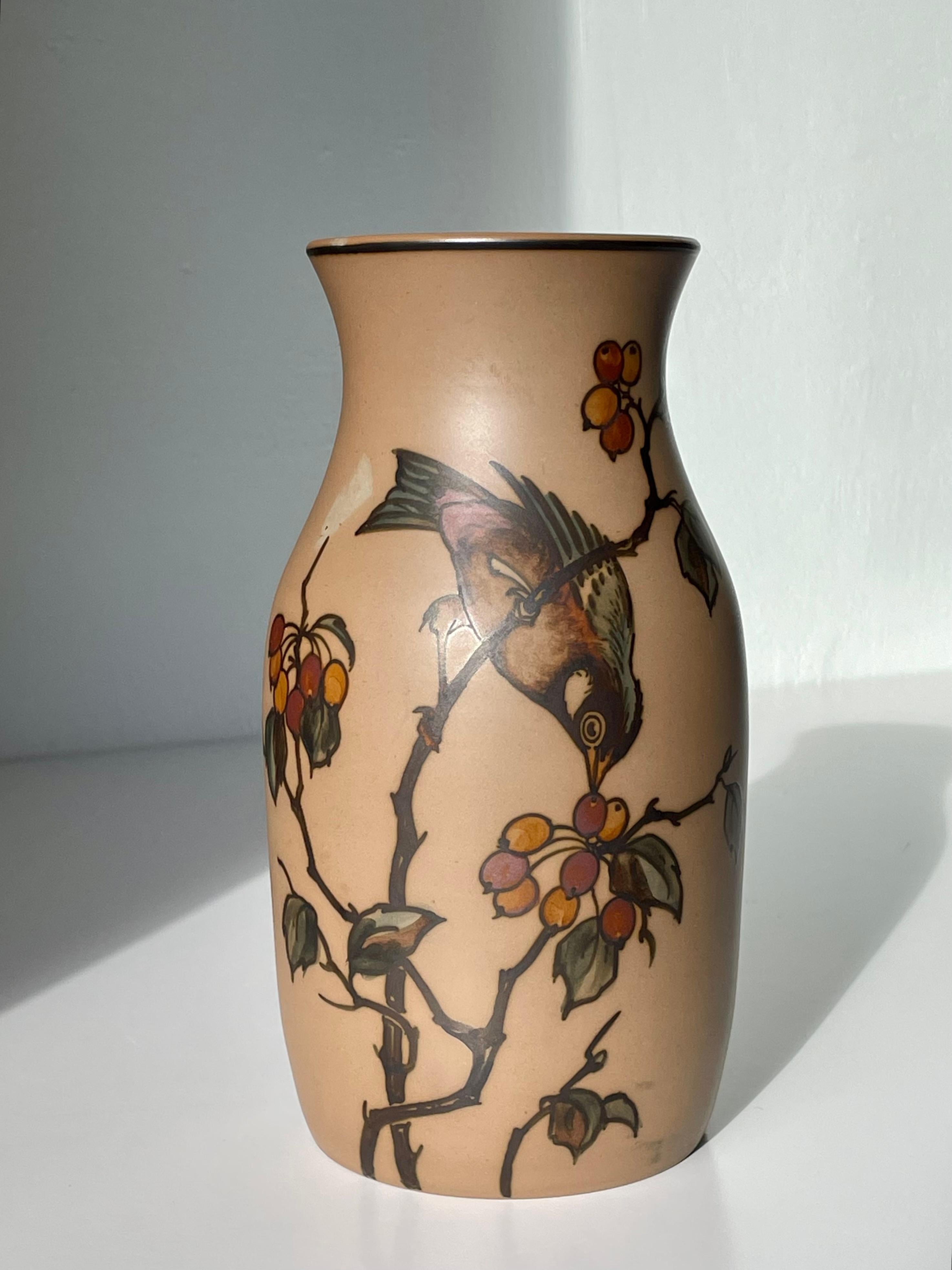Vase Art nouveau en terre cuite des années 1940 avec des décorations organiques et florales naturalistes peintes à la main, avec un oiseau coloré cueillant des baies sur une Branch. Fabriqué par L. Hjorths Terracottafabrik dans la petite ville de