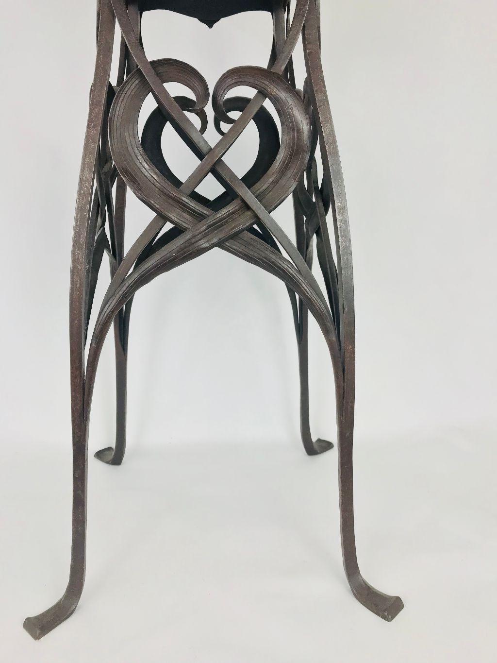 Absolutely outrageous handwrought Art Nouveau stand, circa 1900. Iron base with excellent patina supports a steel top with repousse brass border and riveted iron corner brackets. Attributed to German sculptor Hermann Obrist (1863-1927). Tabletop is