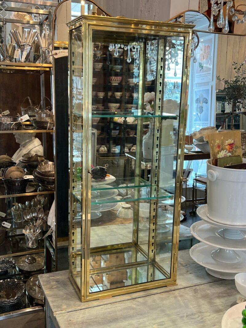 Handsome, and very presentable brass display cabinet from circa 1900s France, in classic Art Nouveau style, which is seen in the charming brass shelf brackets.

Equipped with a large key lock glass door, 2 adjustable glass shelves and mirrored glass