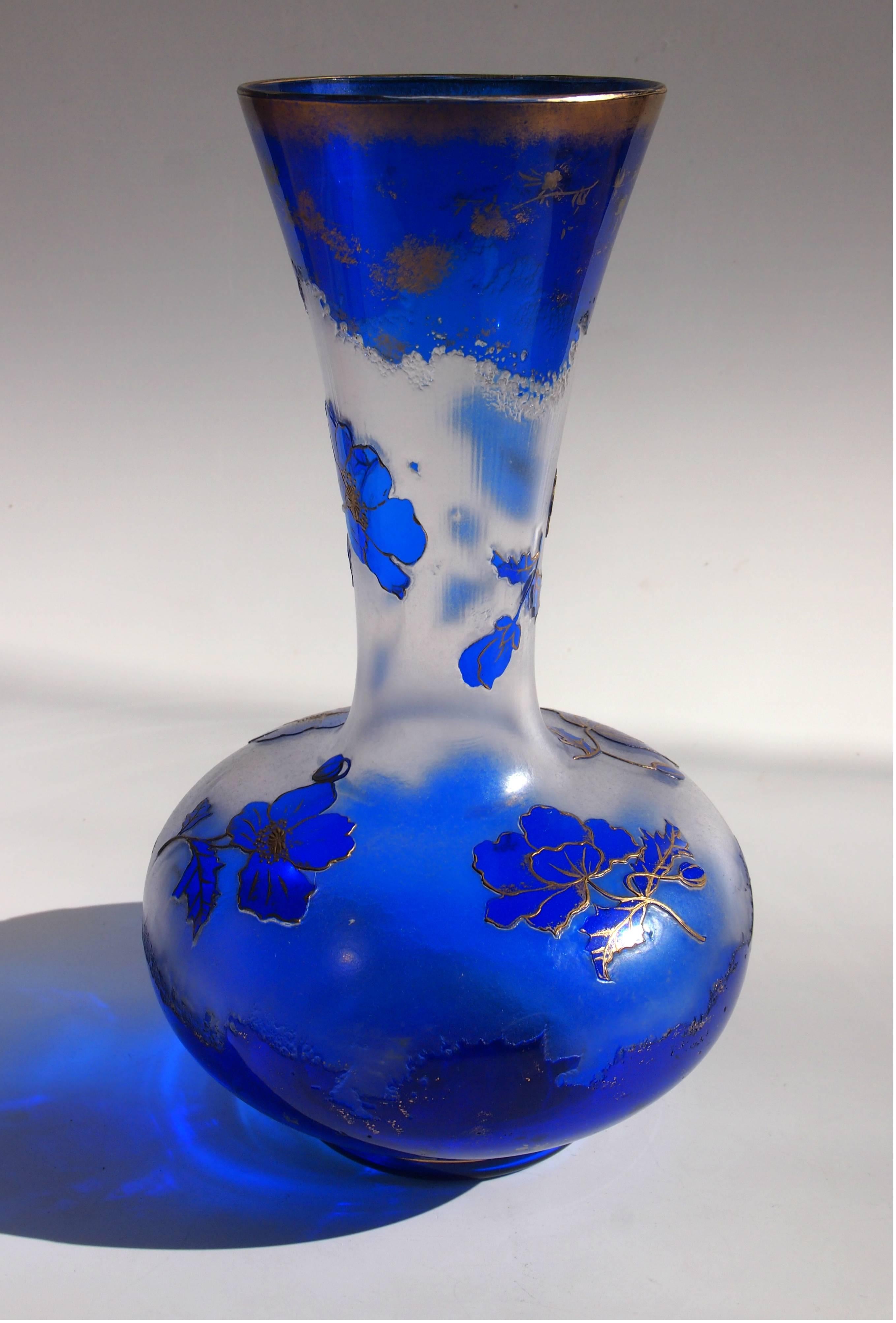 A vibrant Art Nouveau blue over clear Harrach cameo vase. Depicting flowers highlighted with gilding. This style of Cameo was taken by Harrach to the 1900 Paris exhibition. Their stylized cameo technique employed an icicle effect -visible just below