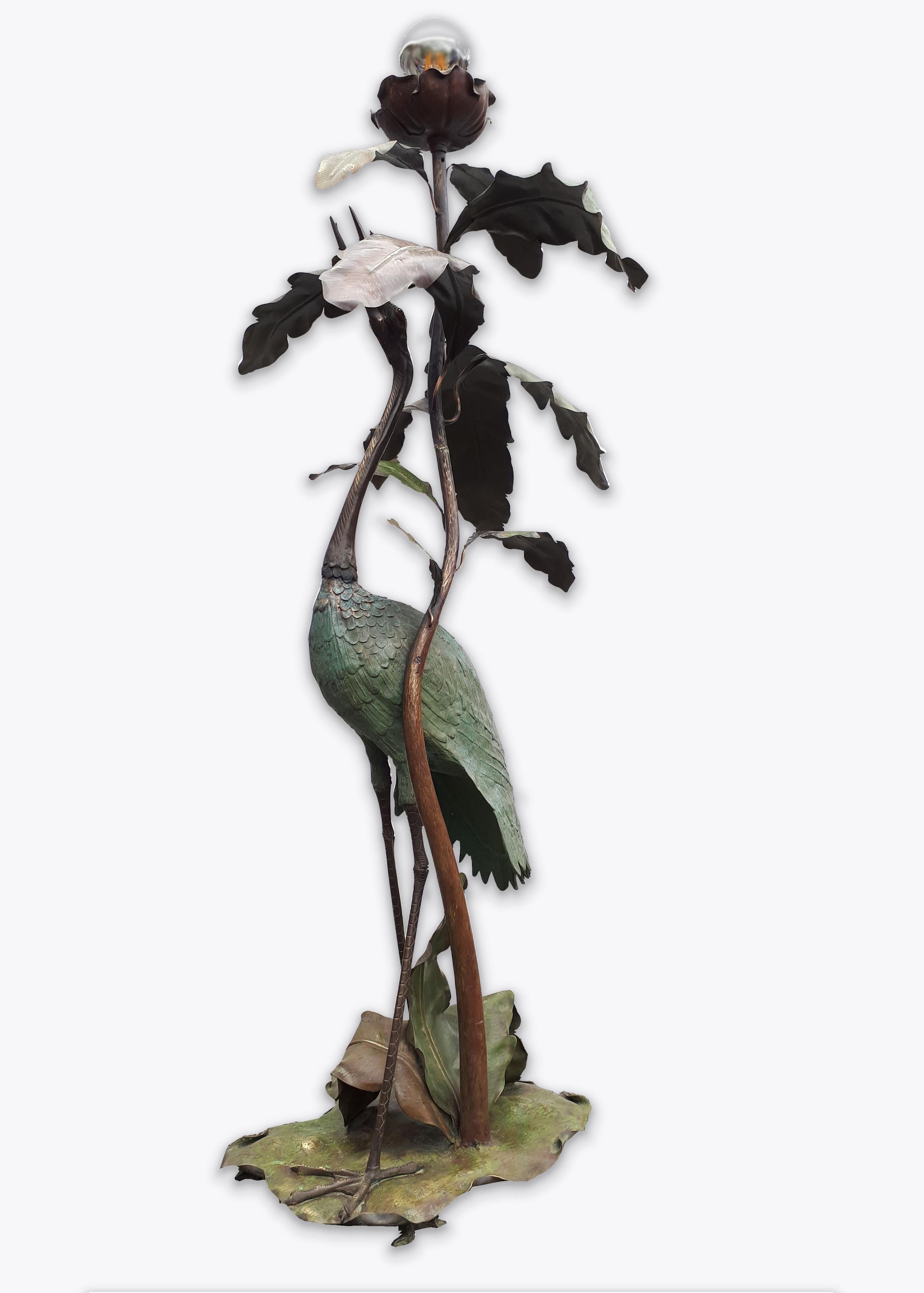 Art Nouveau heron bird and leaves floor lamp from the early 20th century. A very rich executed floor lamp consisting of a beautiful heron that is looking upwarts to a flower holding the light, surrounded with hand crafted chased brass leaves,