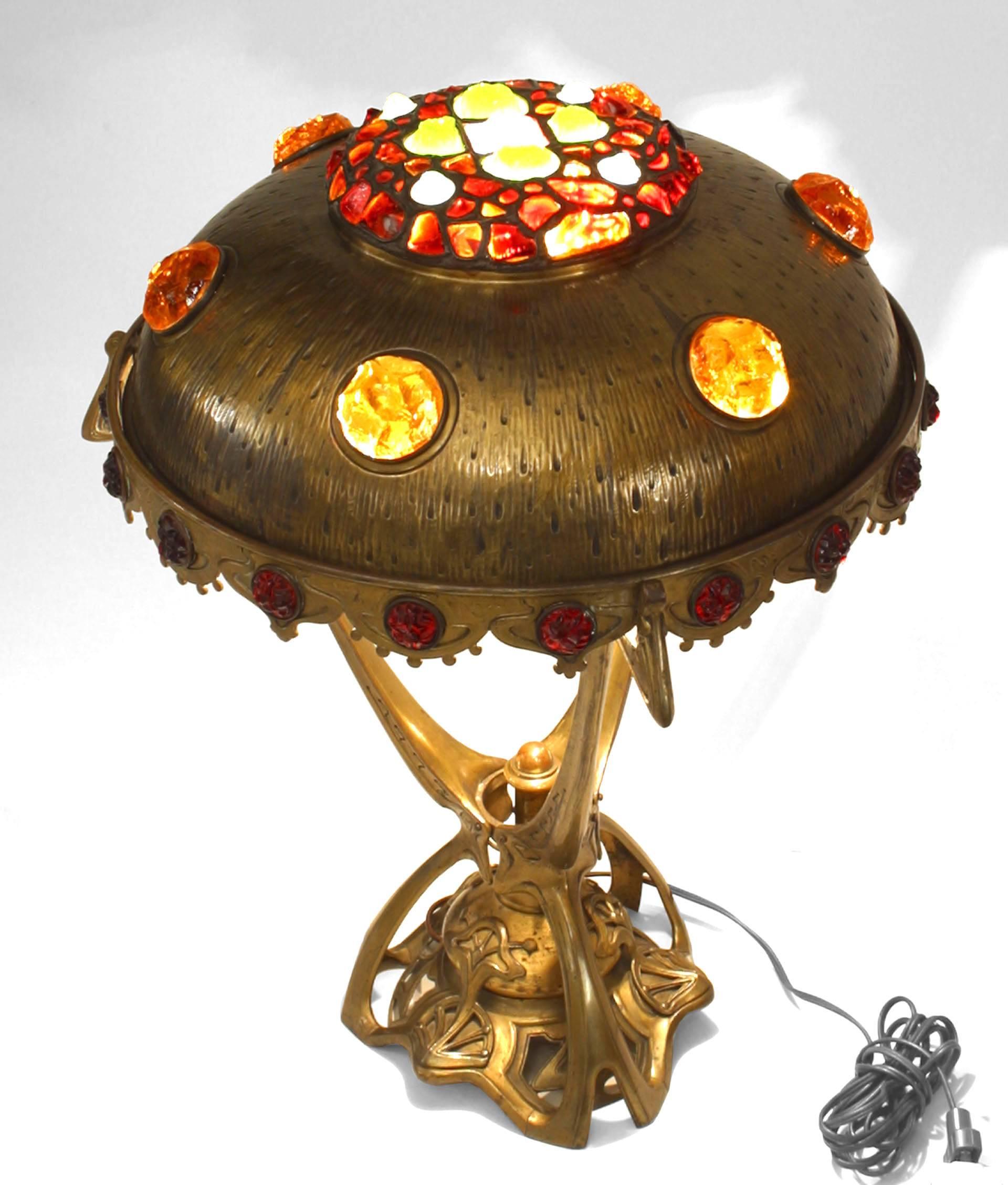 Art Nouveau (Hungarian) brass table lamp with a multicolored glass jewel encrusted shade with 3 supports on a filigree base.
