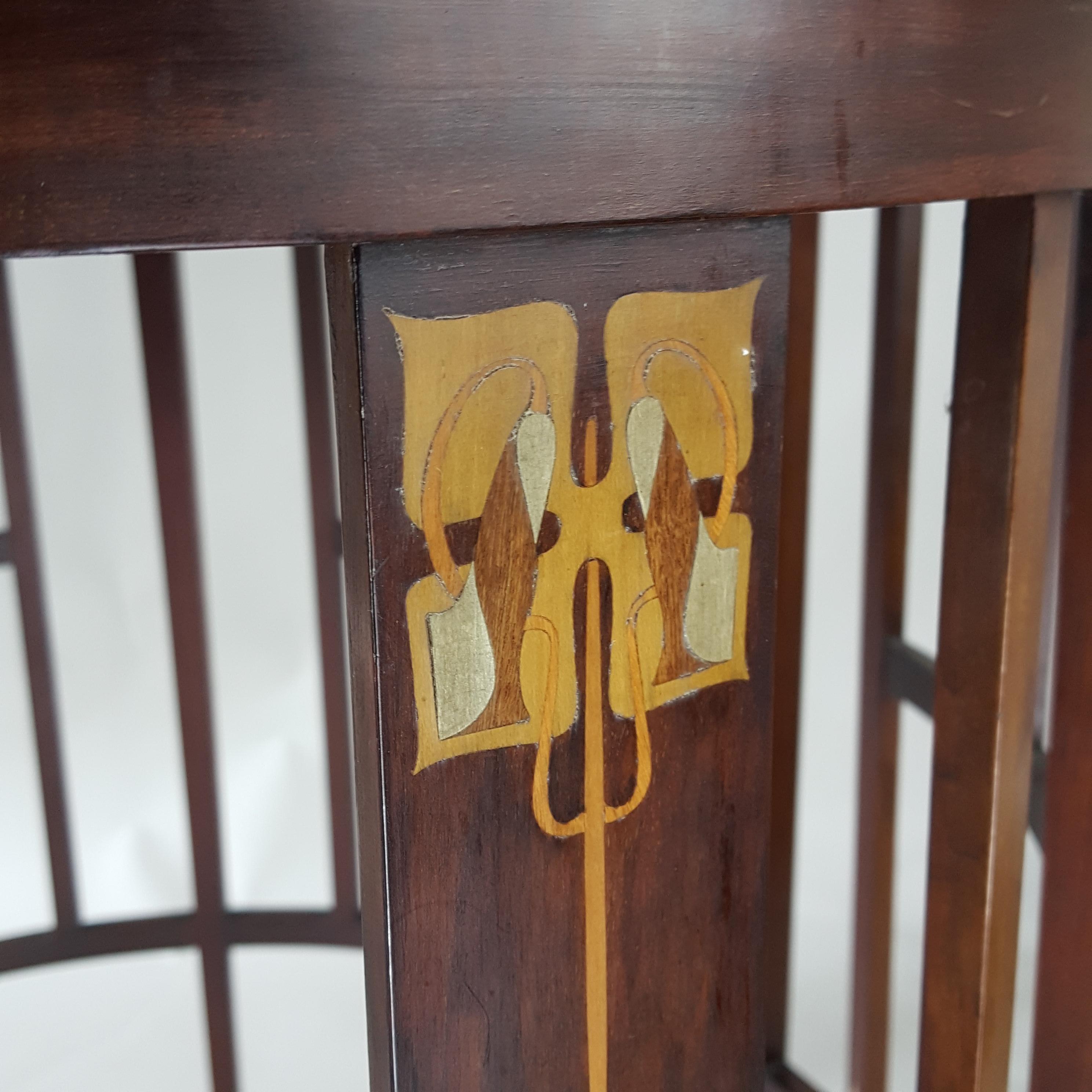 Stylish original English Art Nouveau mahogany inlaid circular centre table attributed to J S Henry circa 1900. The table has stylised fruit wood and pewter inlaid decoration. It is in good original condition although there are stains to the top