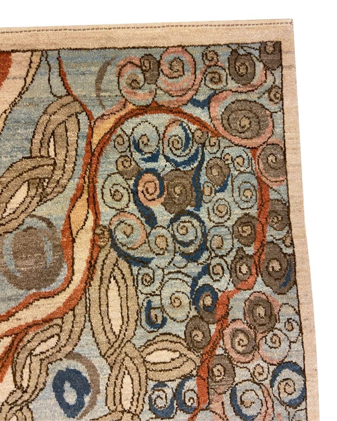 Esta alfombra persa de lana azul, crema, marrón, rosa y roja inspirada en el Art Nouveau, de 1,80 x 1,80 m, presenta una hermosa fusión de intrincados diseños y ricos colores. El motivo abstracto fluye orgánicamente, combinando formas arremolinadas,