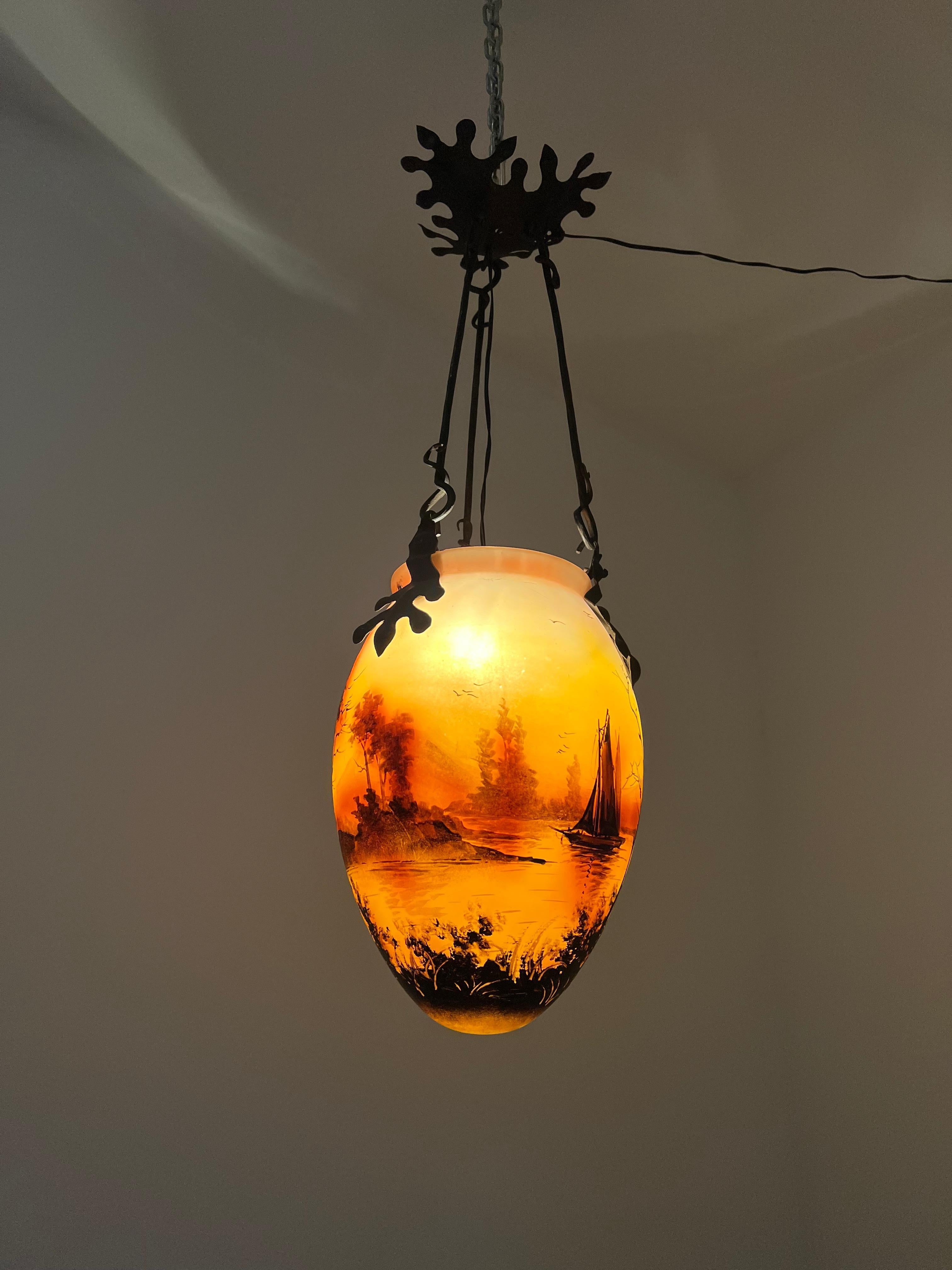 Small pendant light manufactured in France circa 1900 in hand-forged Iron and pâte de verre glass.
The glass Vase is manufactured in the pâte de verre technique and hand decorated. It is signed 