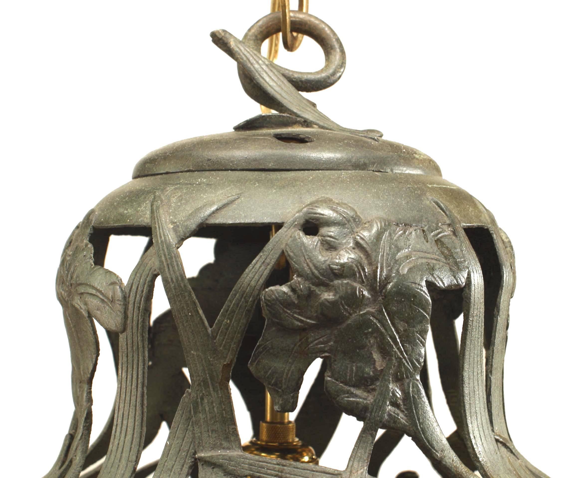 Art Nouveau iron lantern with green patina and tapered round shape with filigree floral and butterfly design and scroll top hook.
 