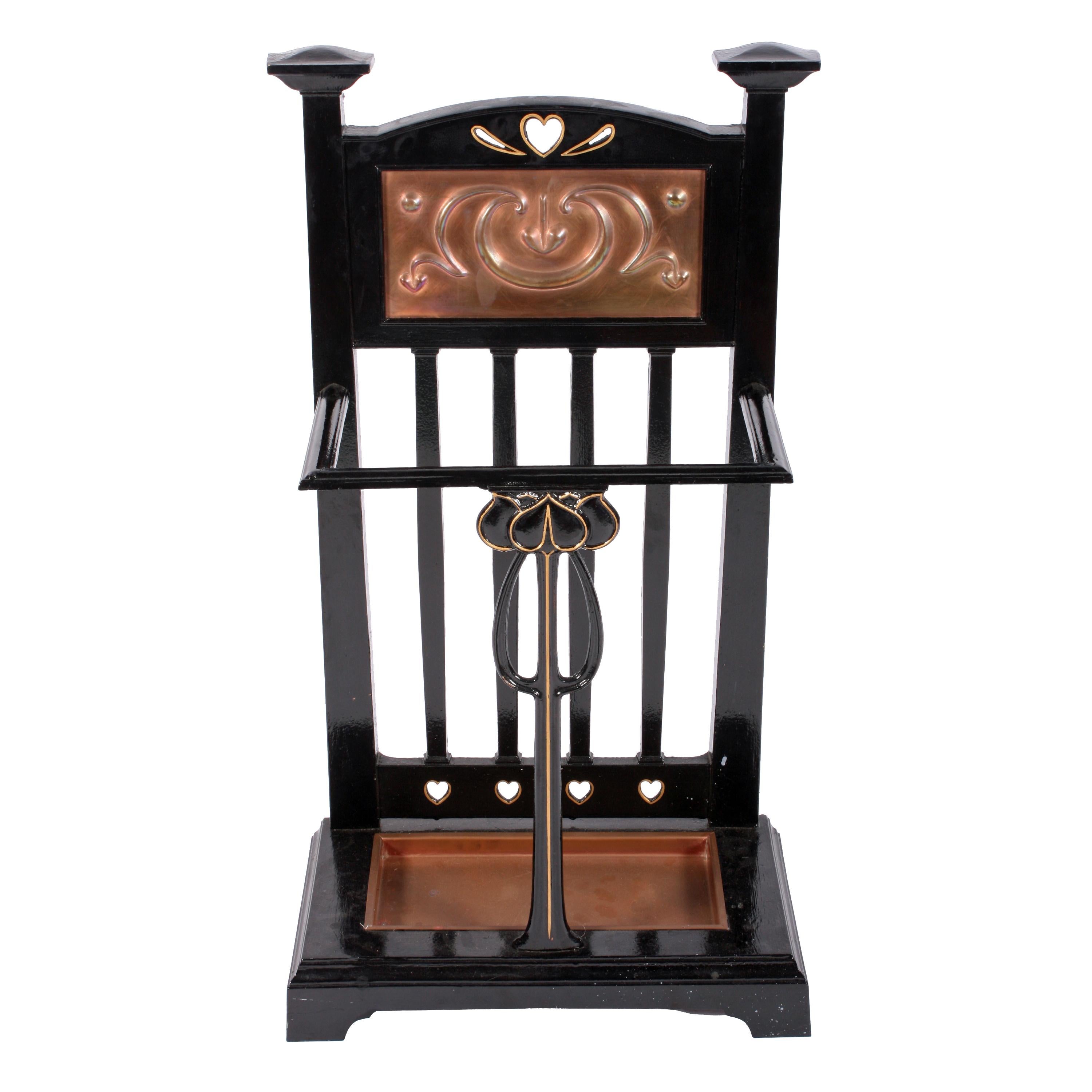 An early 20th century Edwardian cast iron stick and umbrella stand.

The Art Nouveau design cast iron frame is black painted and highlighted in gilt with a decorative copper panel and drip tray.

The stand has cast into the back and underneath