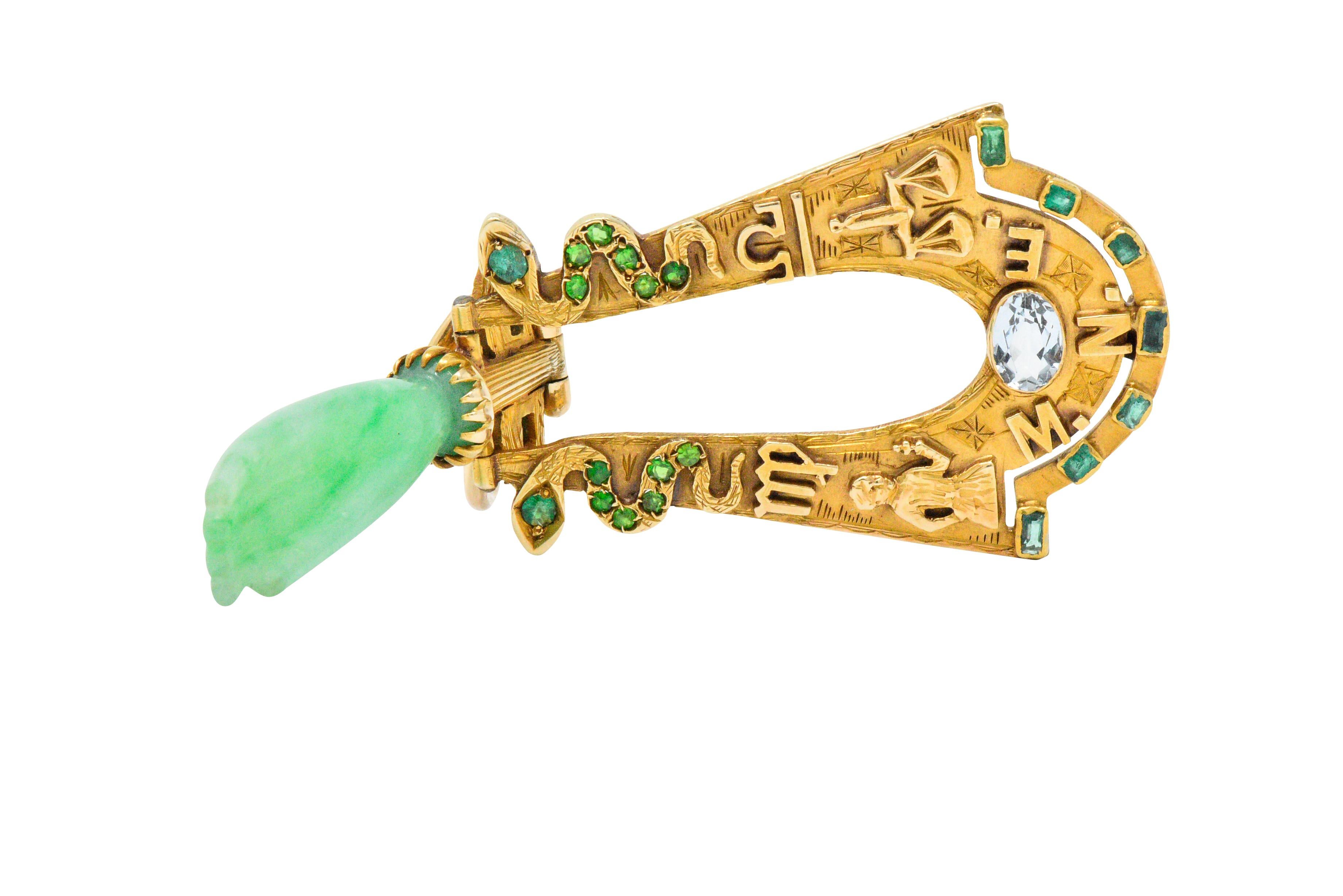 Centering a jade drop carved in the form of a hand, light mottled green
Accented with demantoid garnet and emerald set snakes 
Terminating with an oval cut aquamarine 
Detailed gold work throughout and on verso
Tested to be 18 karat gold
Measuring: