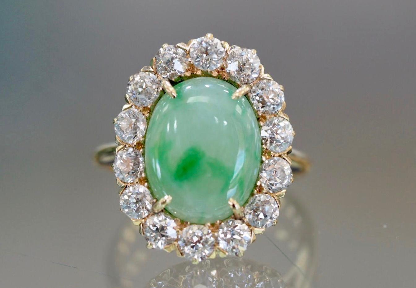 14 Karat Yellow Gold antique Jade Diamond Ring dates back to the late 1890's- early 1910's  includes a natural cabochon shaped Jadeite center with beautiful  sporadic shades of Green. The Jadeite measures 13.00 x 10.23 x 2.75mm with an approximate