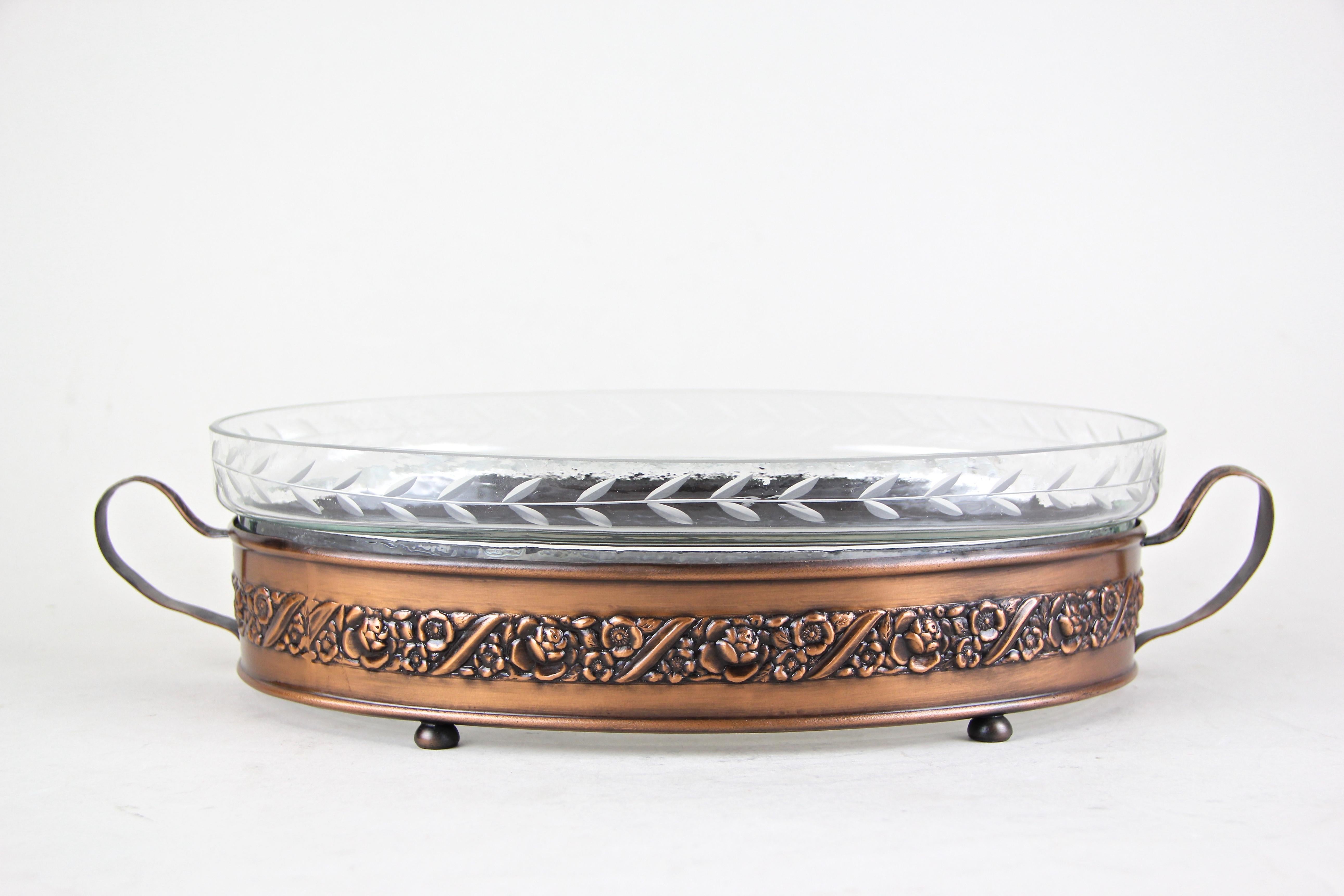 Made of fine copper, circa 1915, this beautiful Art Nouveau jardinière from Austria impresses with a great embossed design adorned by classical roses. The inserted cut glass bowl comes with overhanging ornamented edges and a small engraved star in