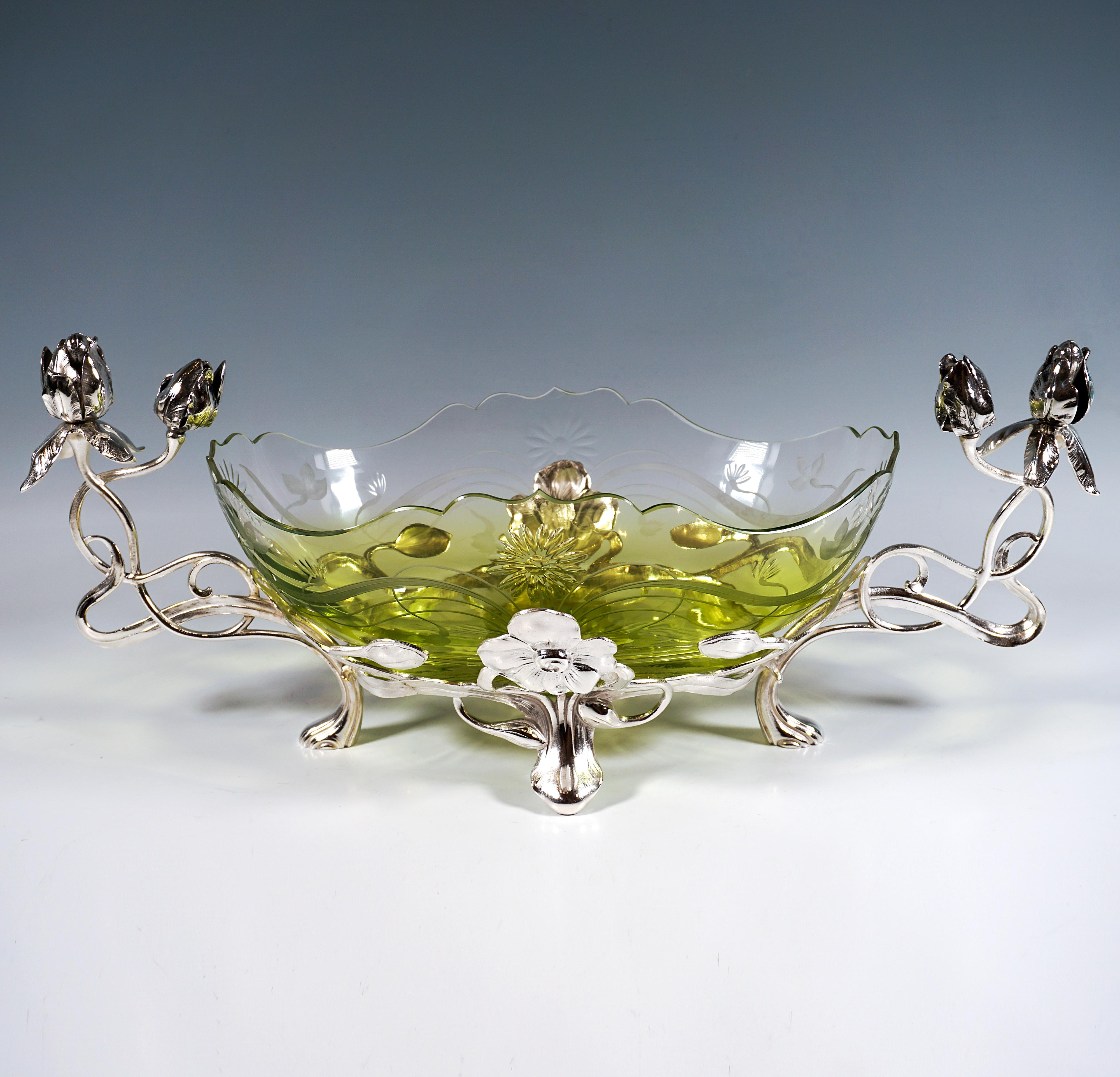 Elaborately designed silver-plated mounting in the form of skilfully intertwined rose tendrils, forming an oval ring with four feet, which serves as a holder for the glass vessel, which is additionally supported at the front and back by two