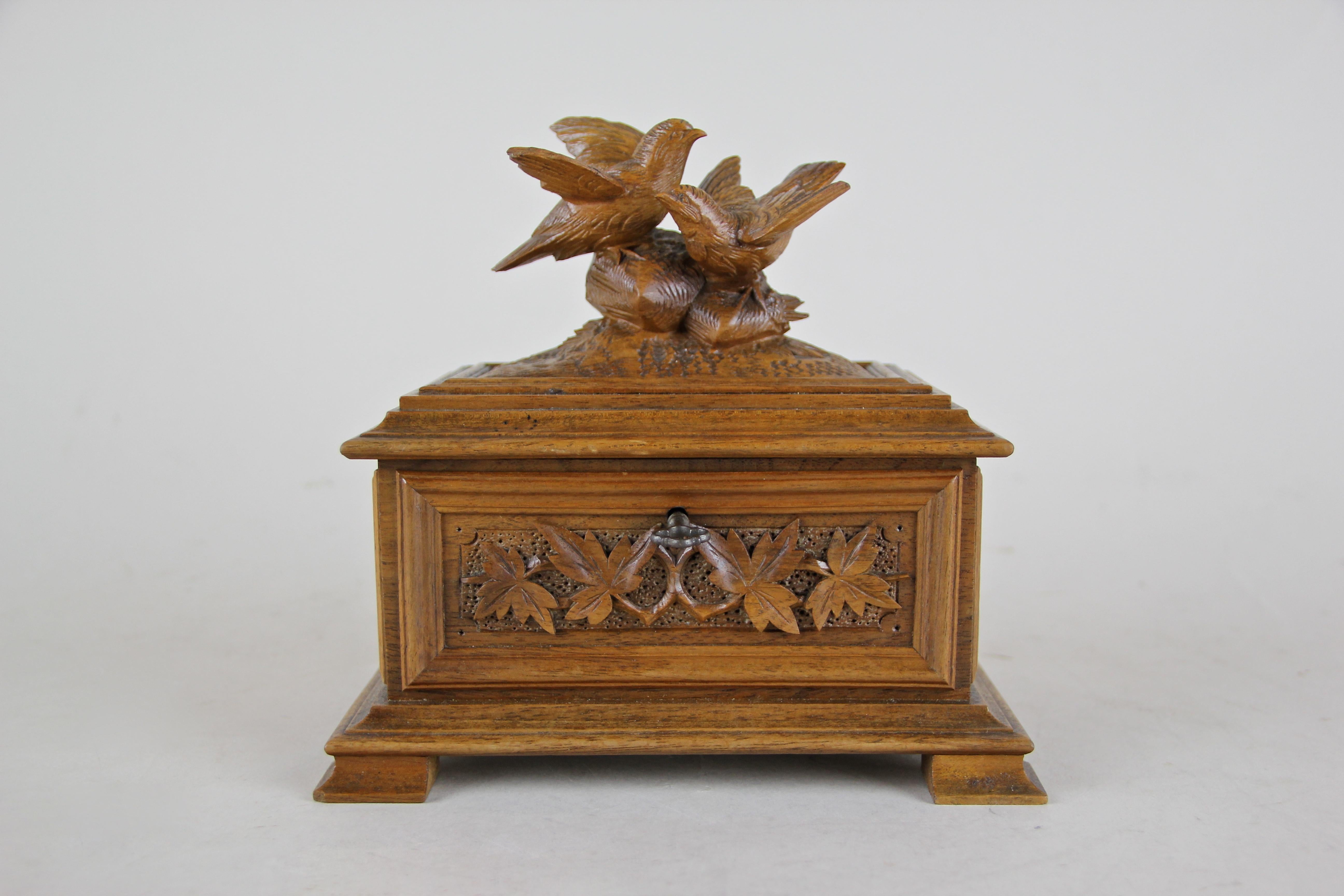 Charming small Art Nouveau jewelry music box out of France, circa 1900. This fantastic wooden box comes with elaborately hand carved details like the beautiful foliage around the body or the lovely birds on the lid. Inside you find a small